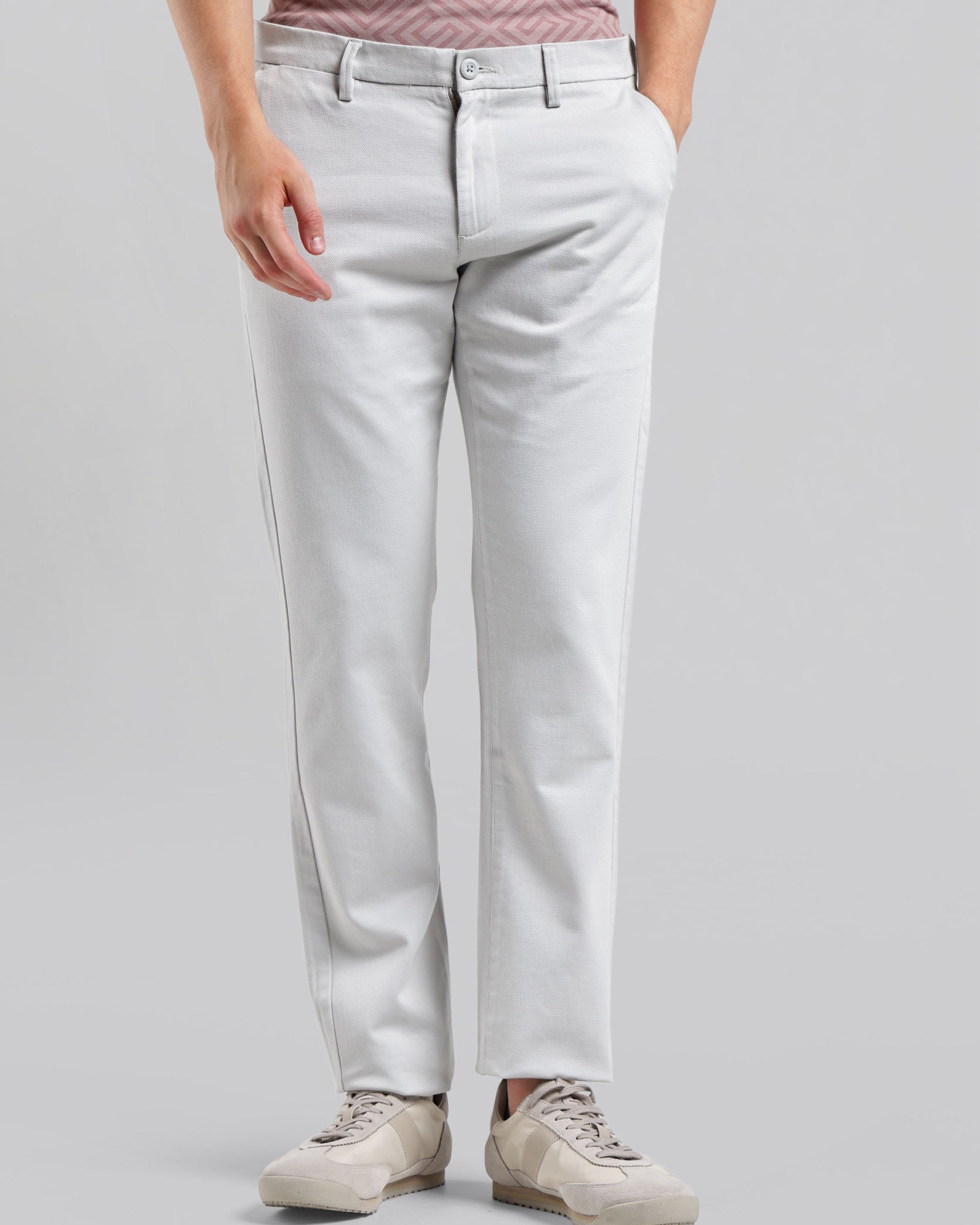 Person wearing light gray jeans on a plain background