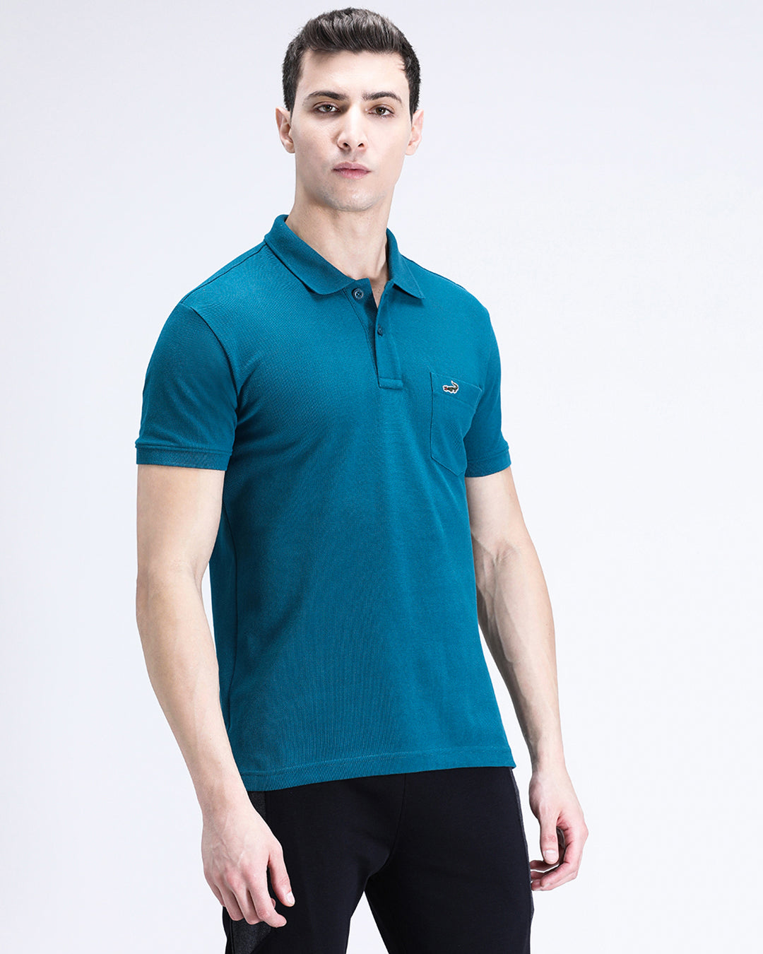 Man wearing a blue blue coral solid polo t shirt with casual styling on a gray background