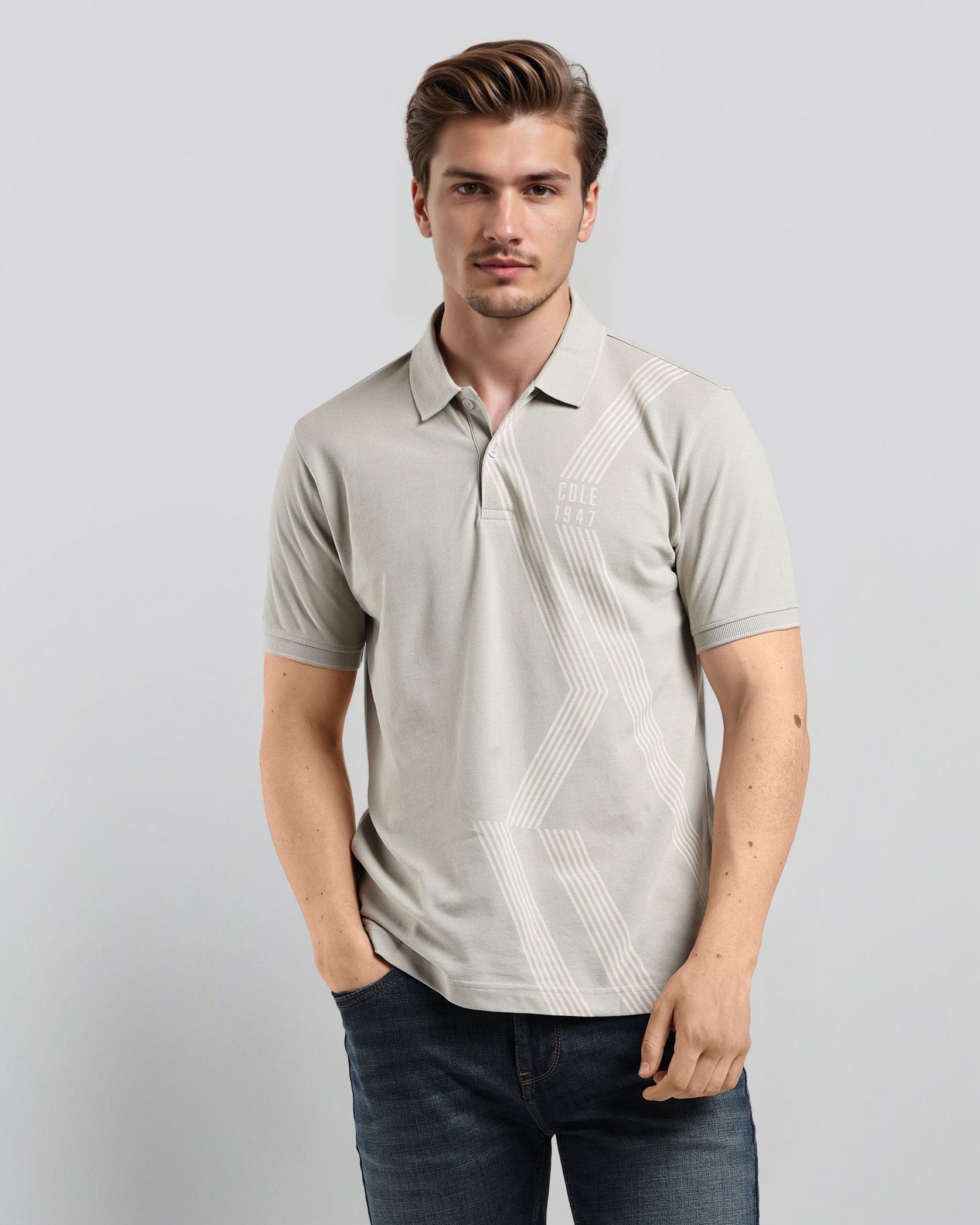 Man wearing a light gray polo shirt with a subtle pattern on a plain background