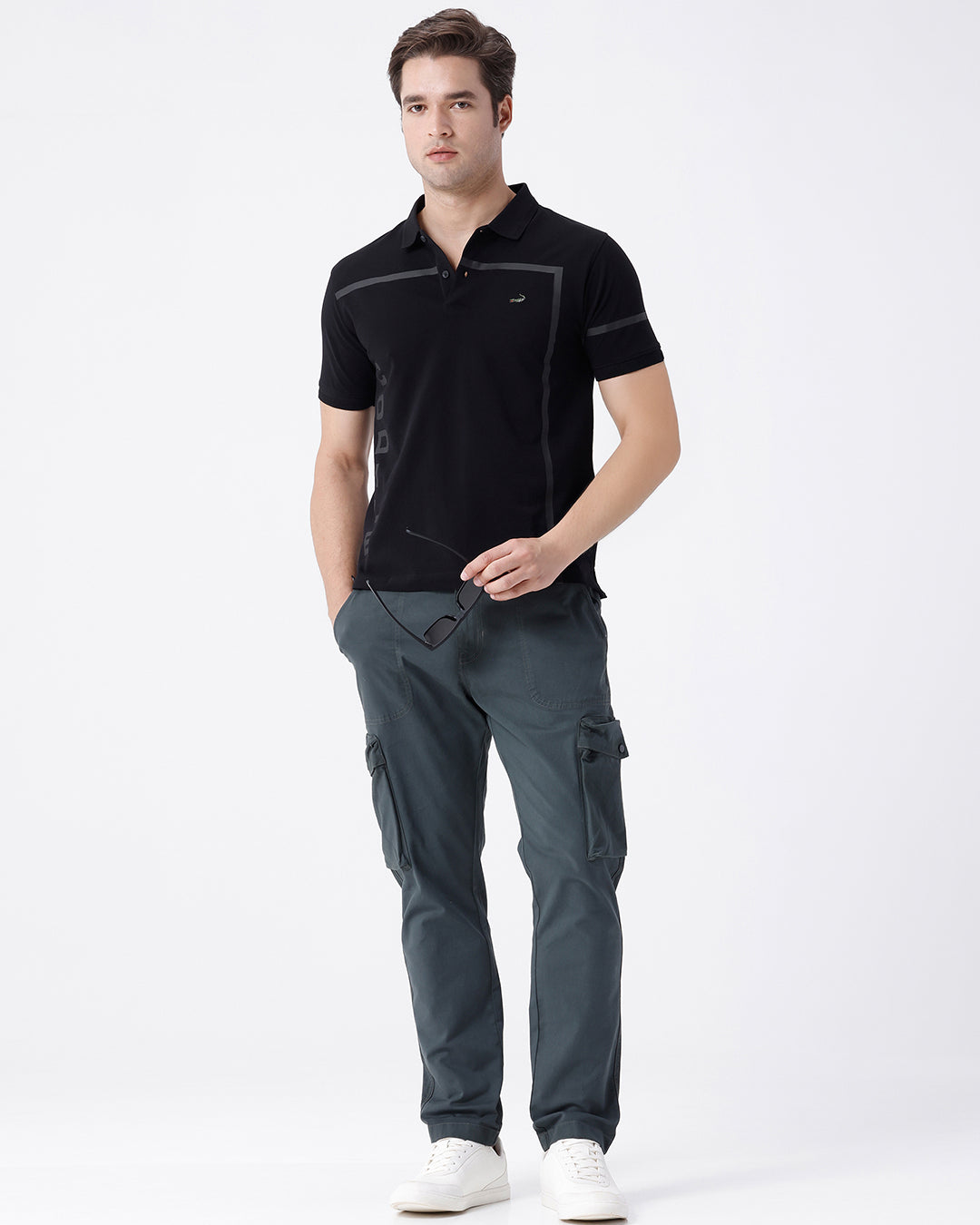 Man wearing a olive garment dyed cargo pant in olive with casual styling on a gray background