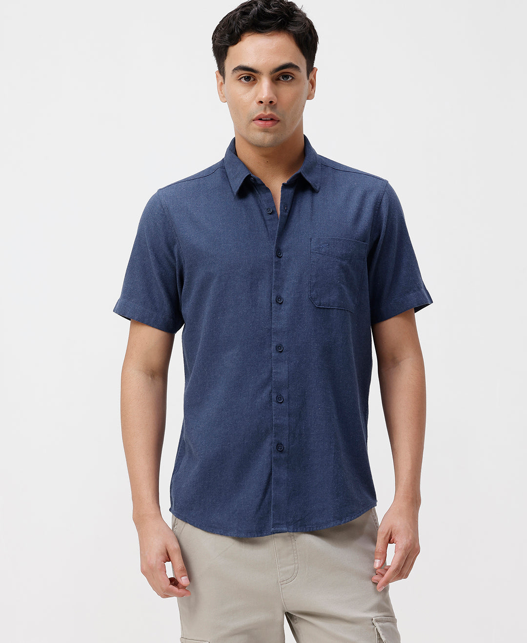 Man wearing a blue melange shirt solid blue on a light gray background