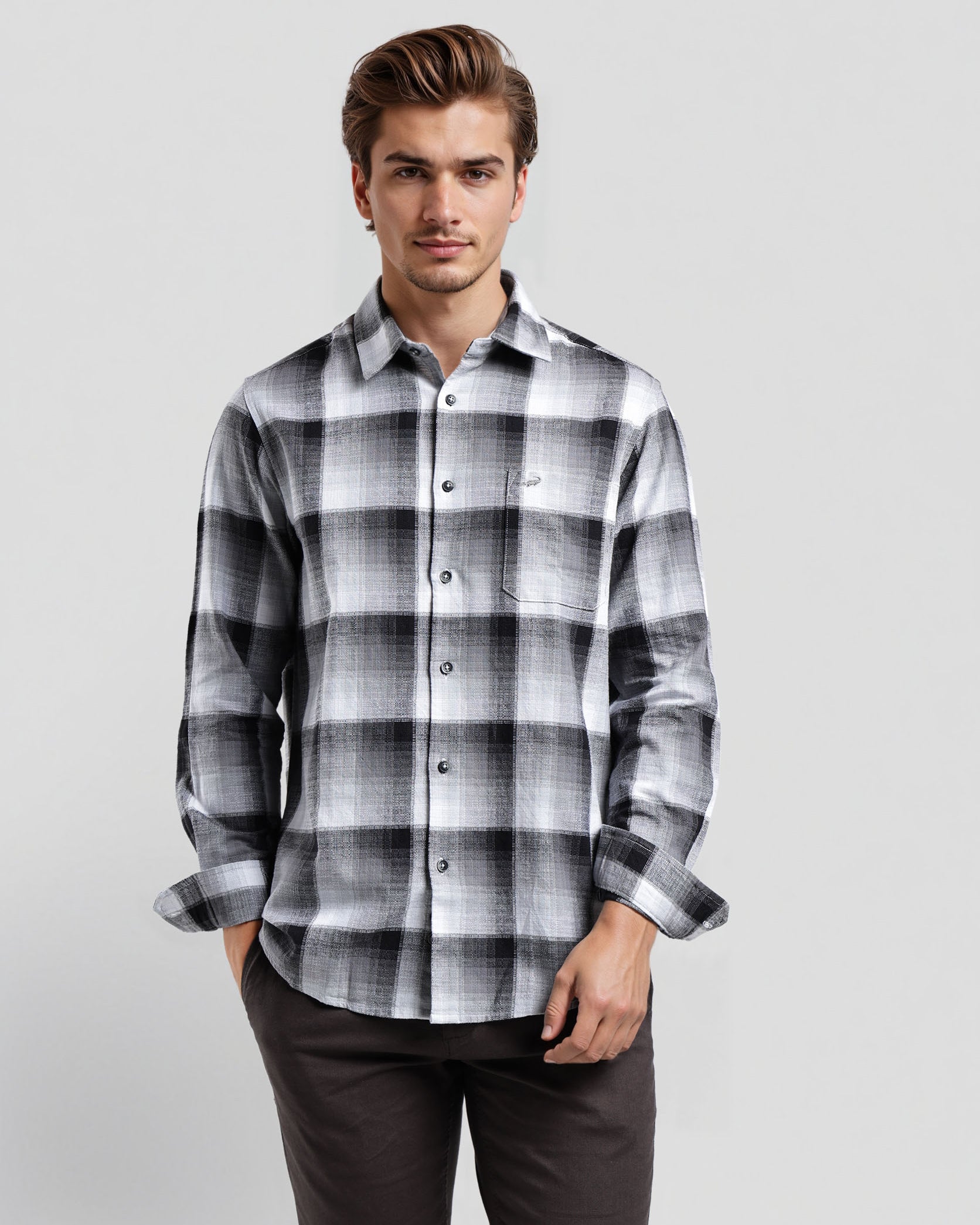 Man wearing a black and white plaid shirt on a light gray background