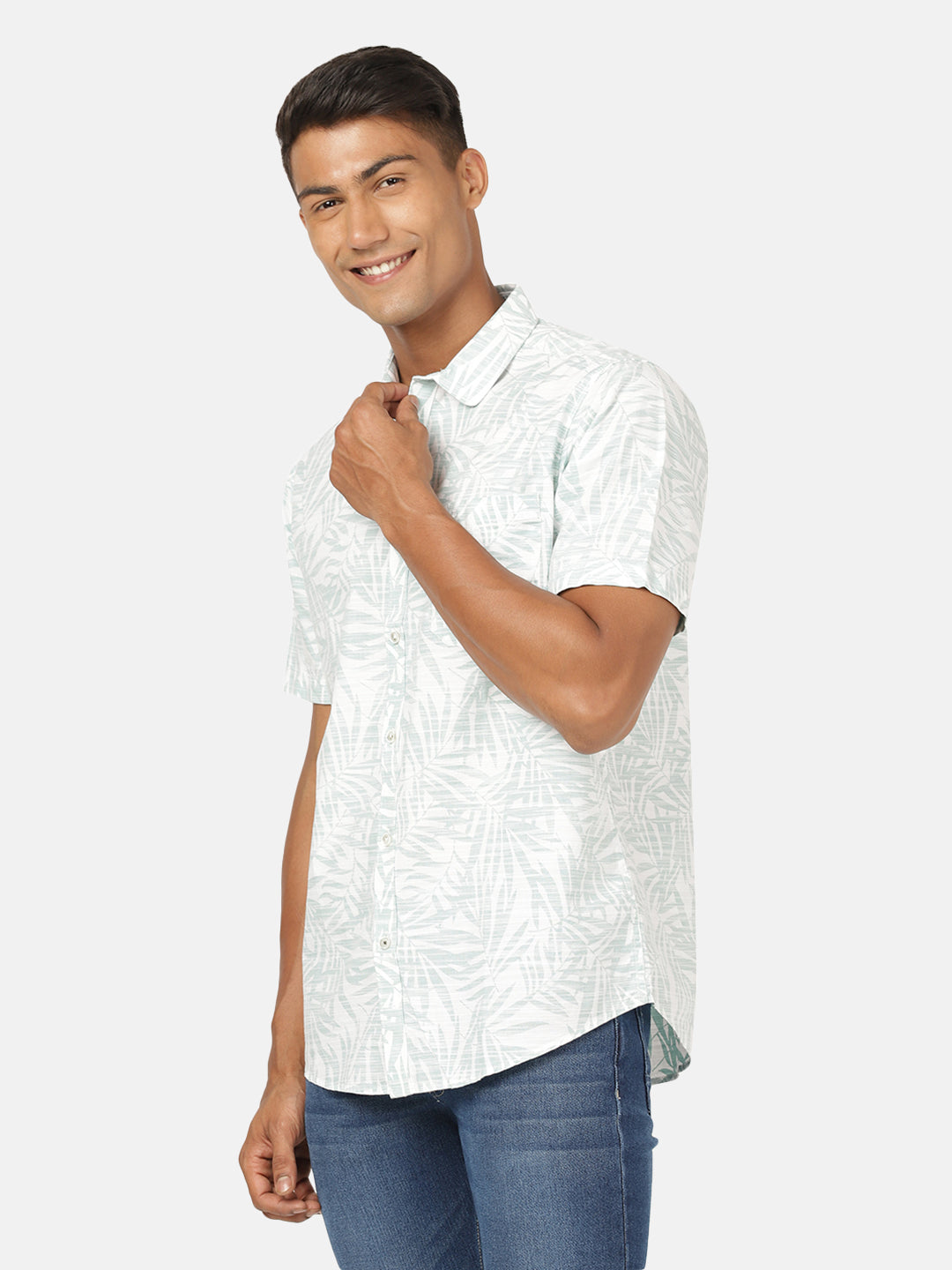 Man wearing a green sea green printed half sleeve 100% cotton shirt on a light gray background