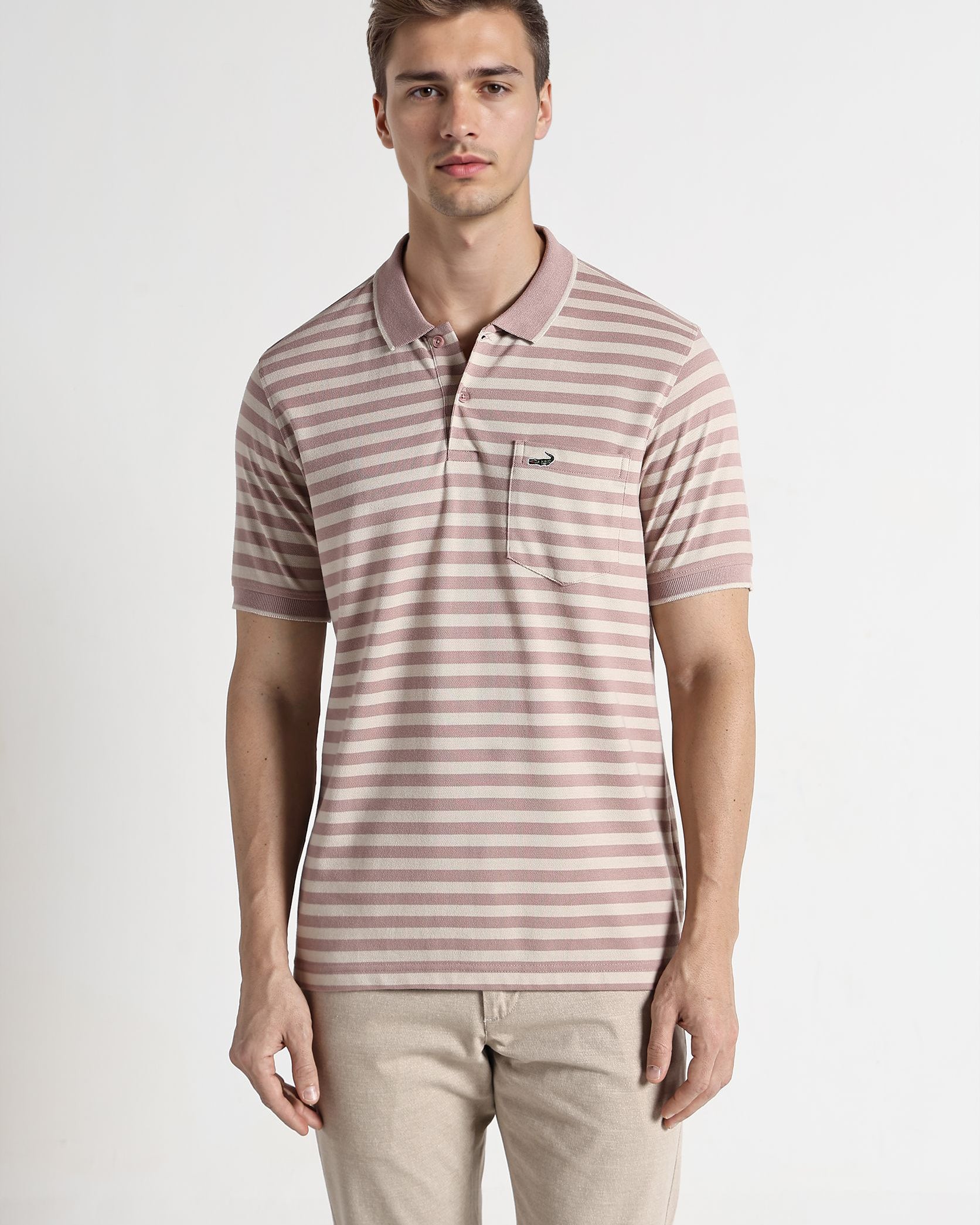 Man wearing a striped polo shirt and beige pants on a white background