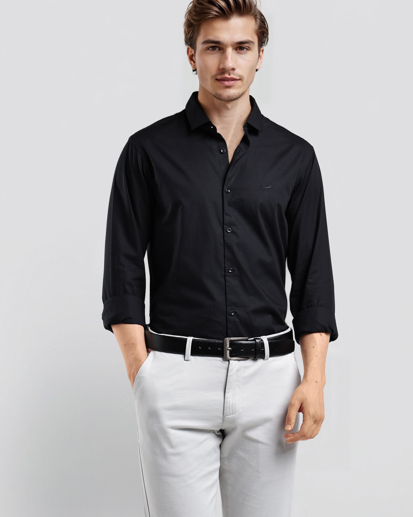 Man wearing a black dress shirt and white pants against a light gray background