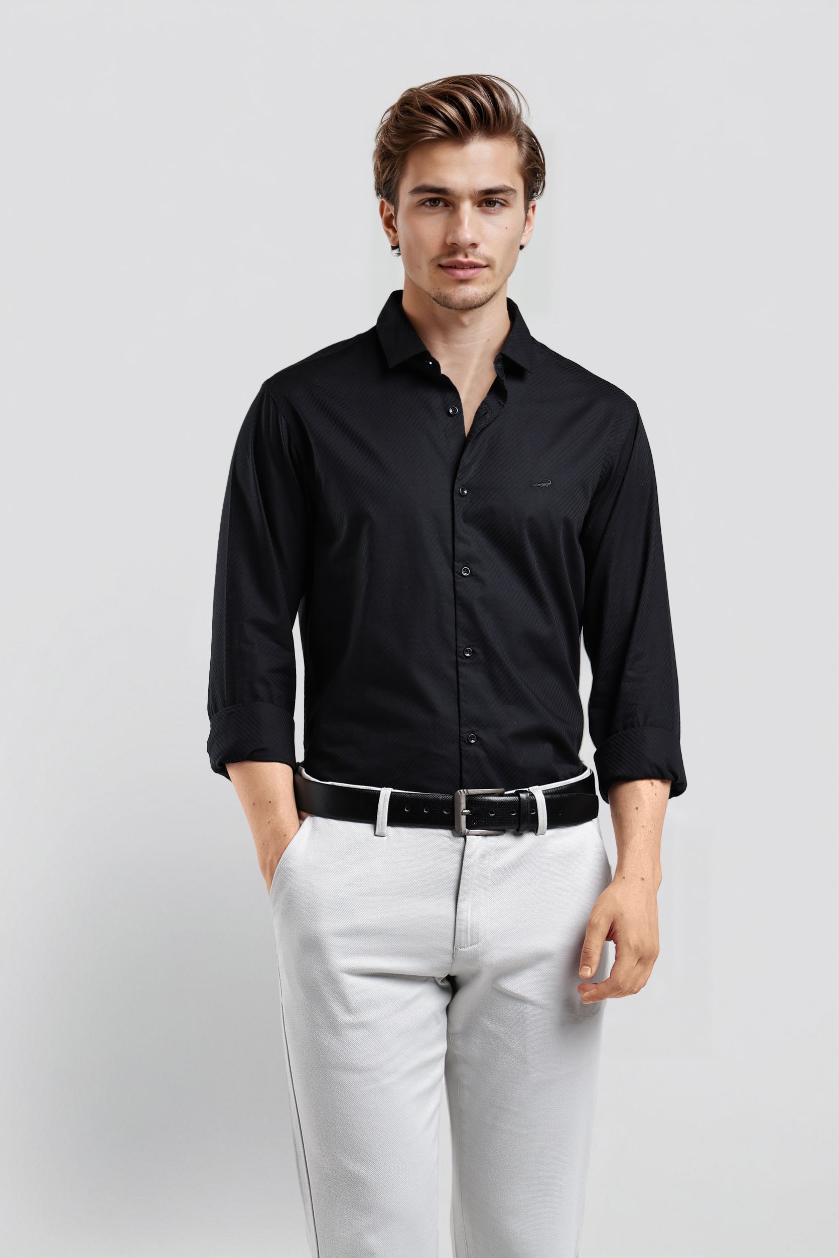 Man wearing a black dress shirt and white pants against a light gray background