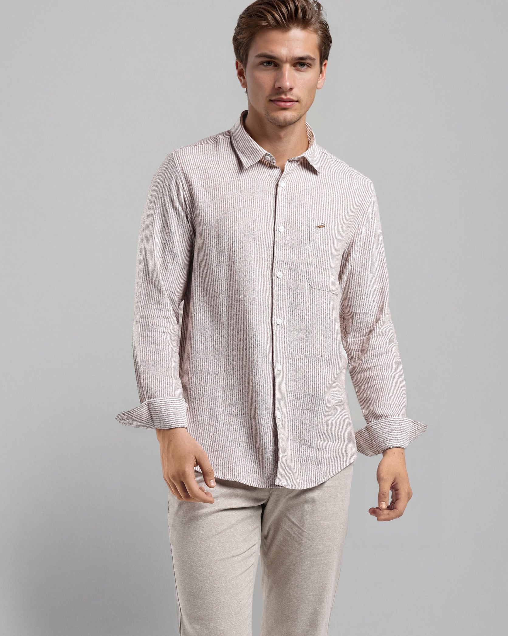 Man wearing a light-colored shirt and pants on a gray background