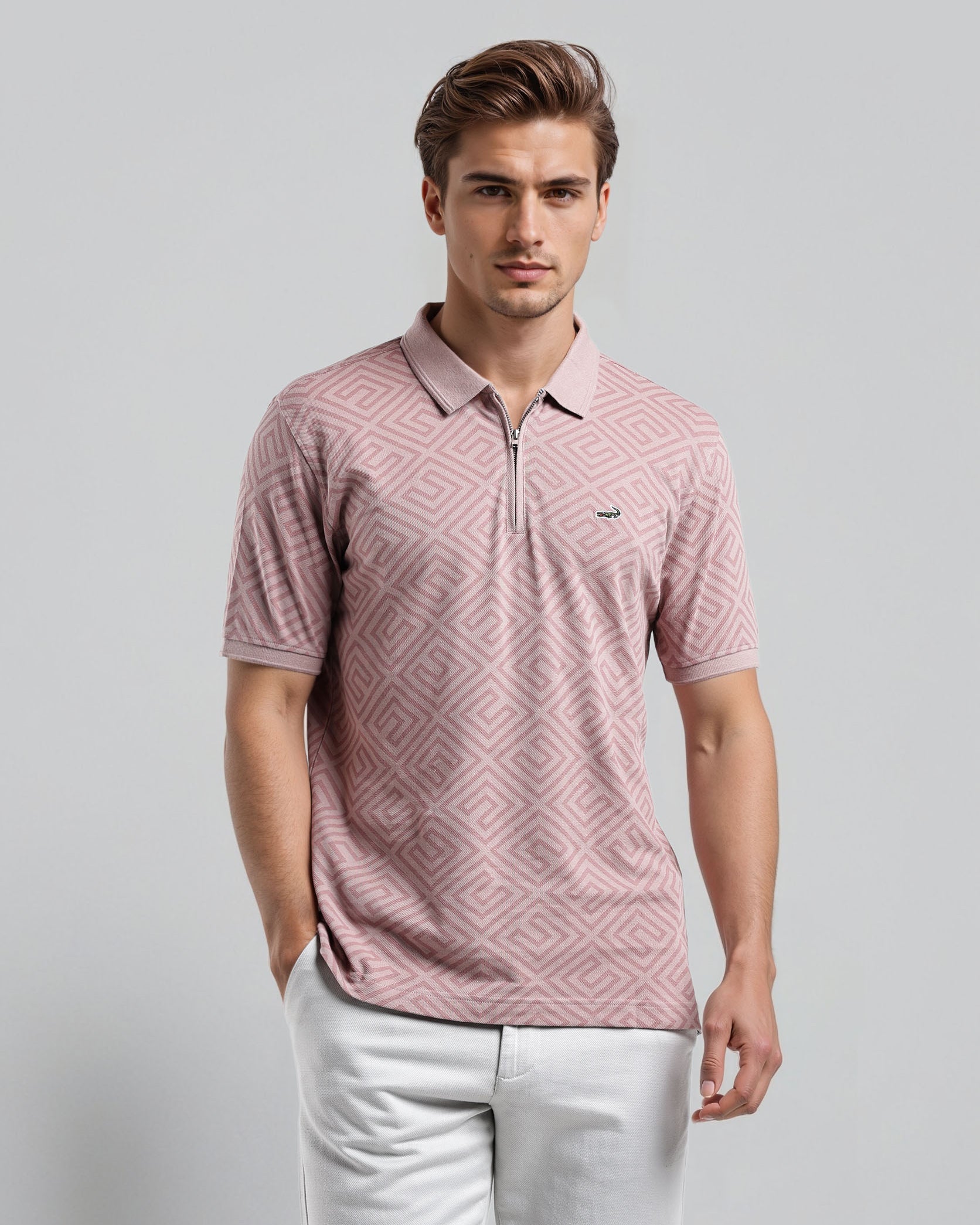 Man wearing a pink patterned polo shirt and white pants against a gray background