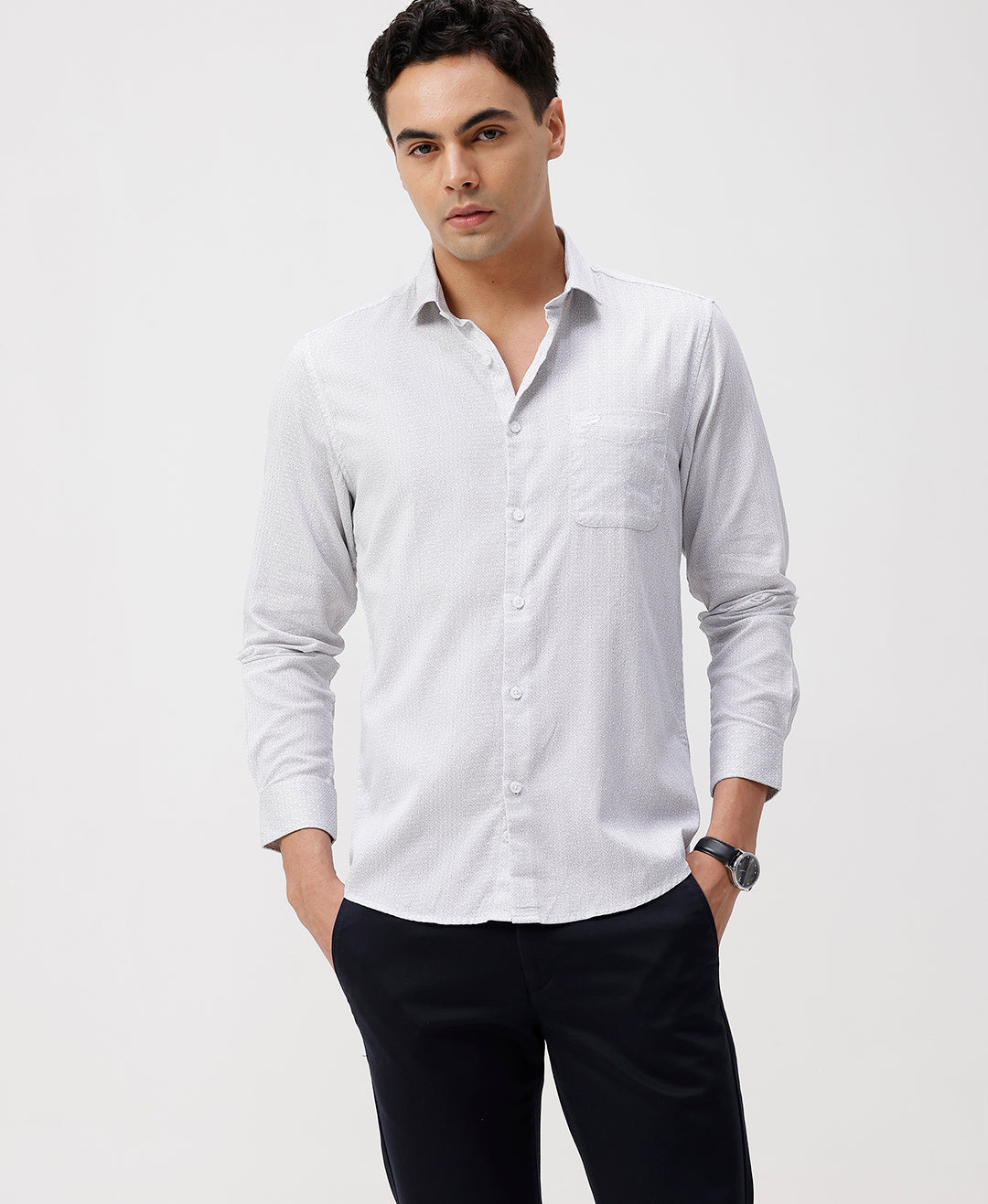 Man wearing a white white all over print slim fit casuals shirts with casual styling on a gray background