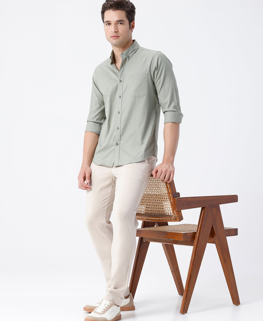 Man wearing a green smart series premium oxford shirt green with casual styling on a gray background