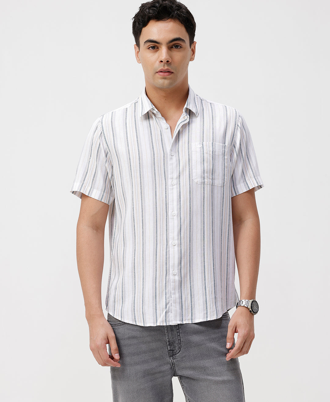 Man wearing a white white and green stripes comfort fit casuals shirts on a light gray background