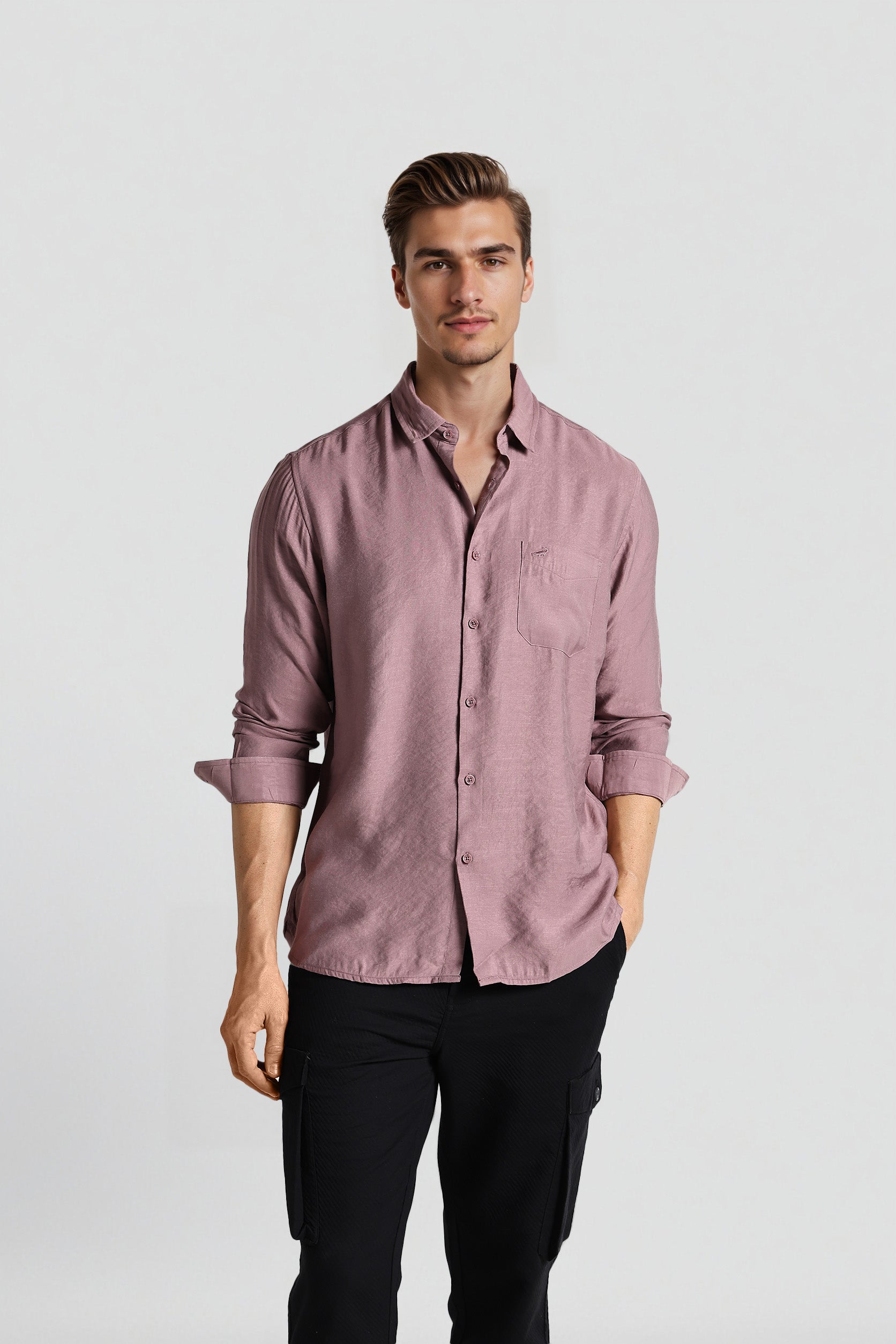 Man wearing a pink shirt and black pants on a white background