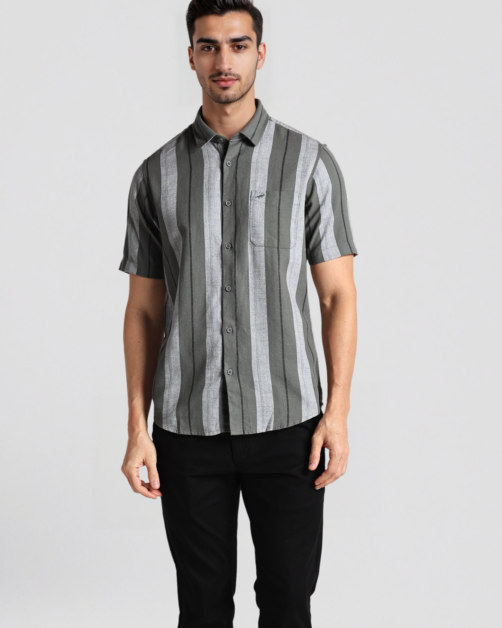 Man wearing a gray and black striped shirt against a plain background