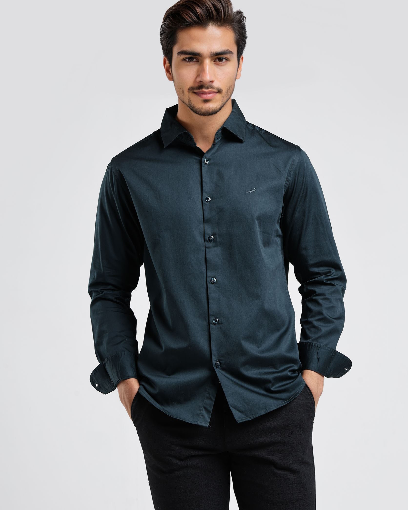 Man wearing a dark green shirt and black pants on a white background