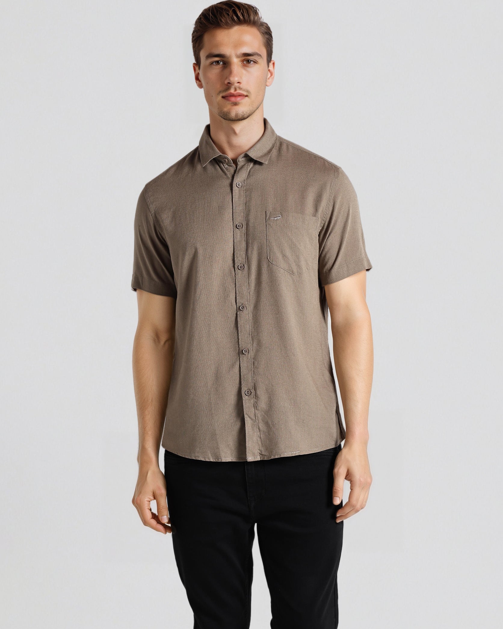 Man wearing a brown short-sleeve shirt and black pants on a white background