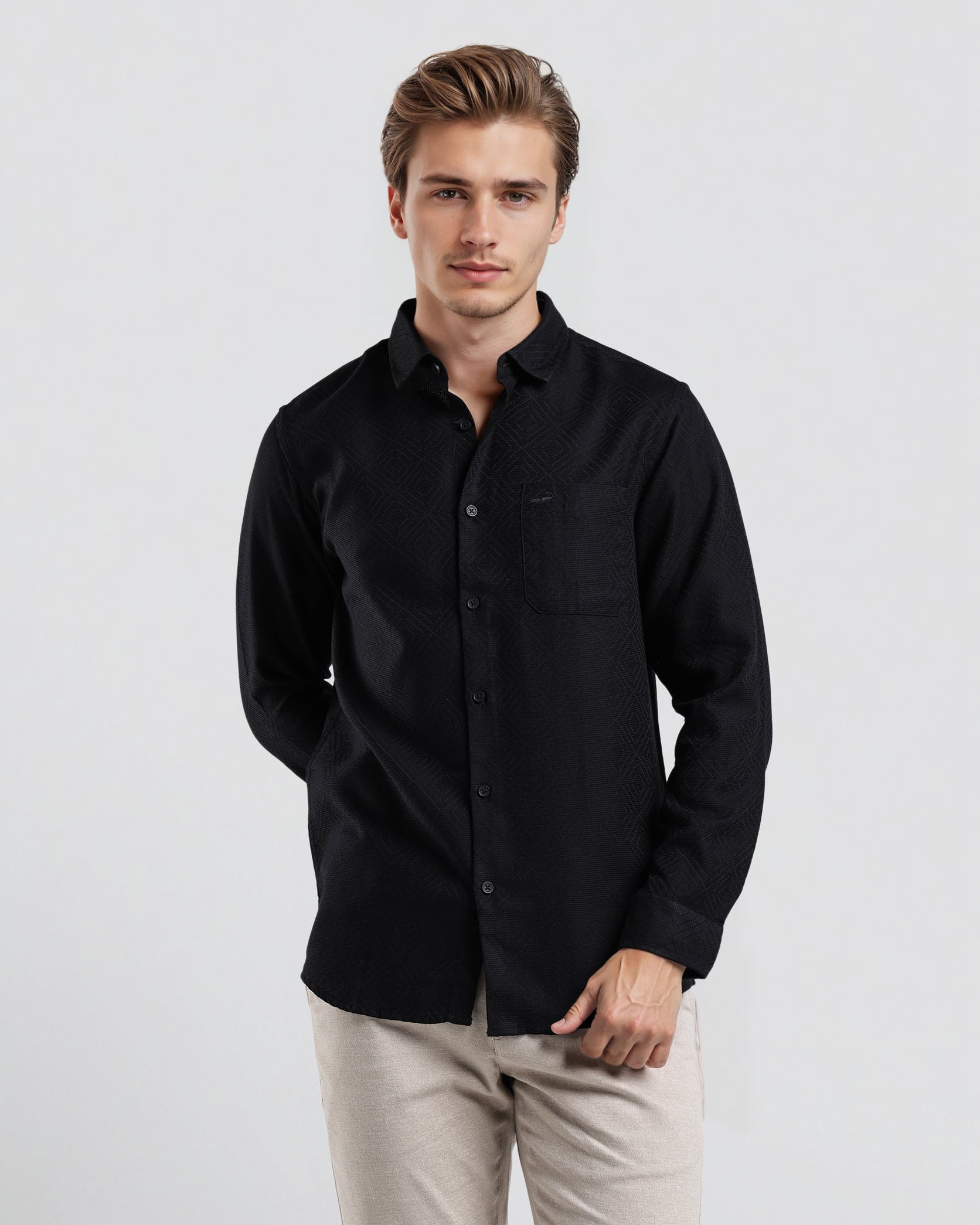 Man wearing a black shirt and beige pants on a white background