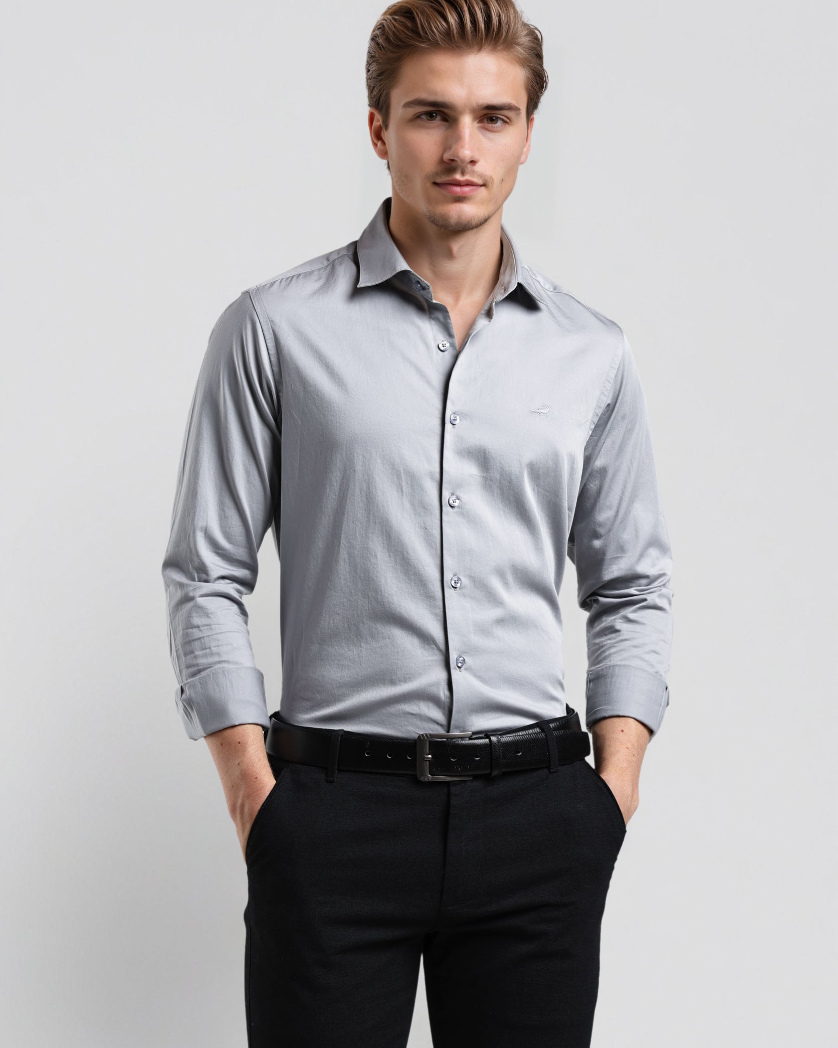 Man wearing a light gray dress shirt and black pants on a white background