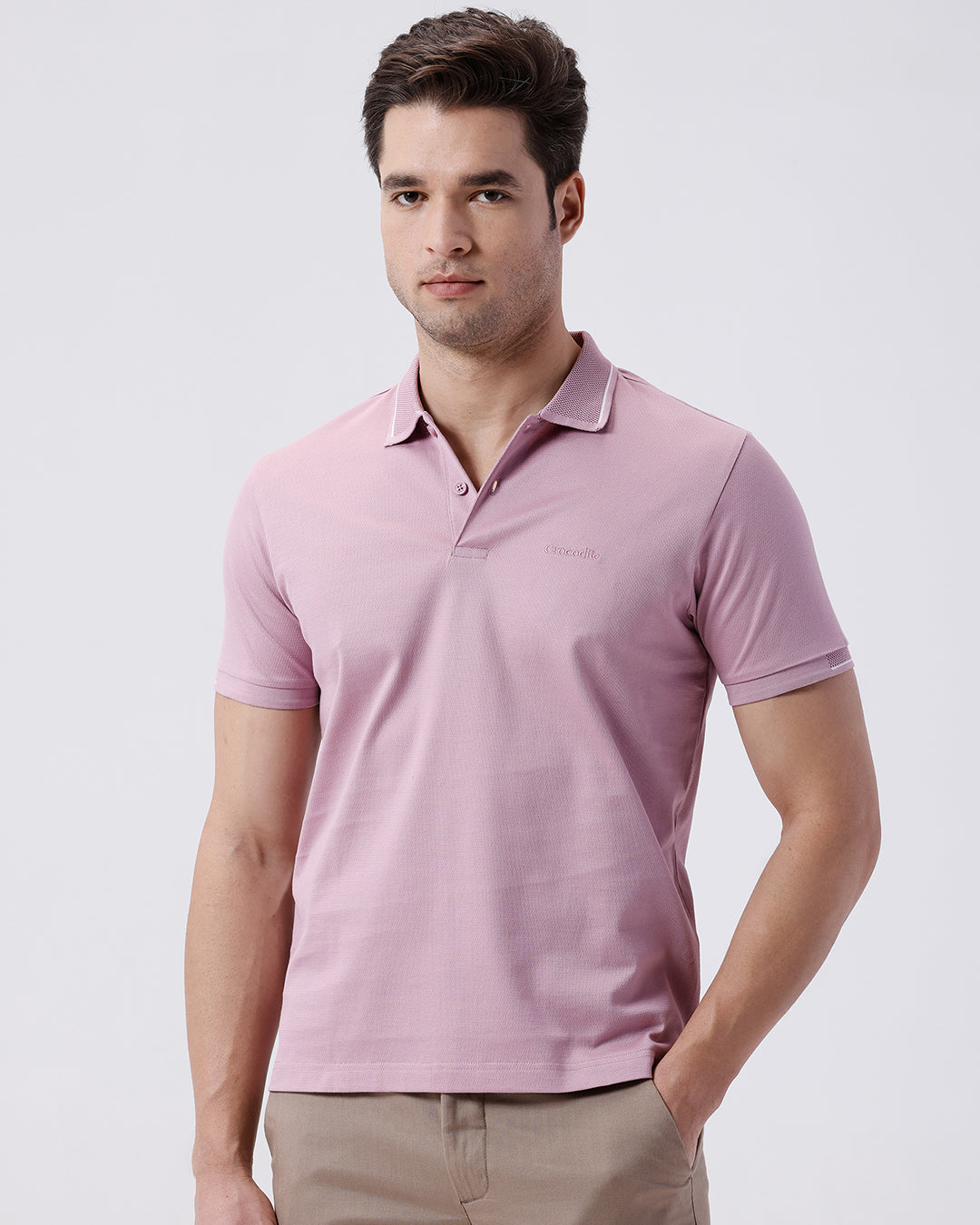 Man wearing a red mercerized subtle textured polo t shirt with casual styling on a gray background