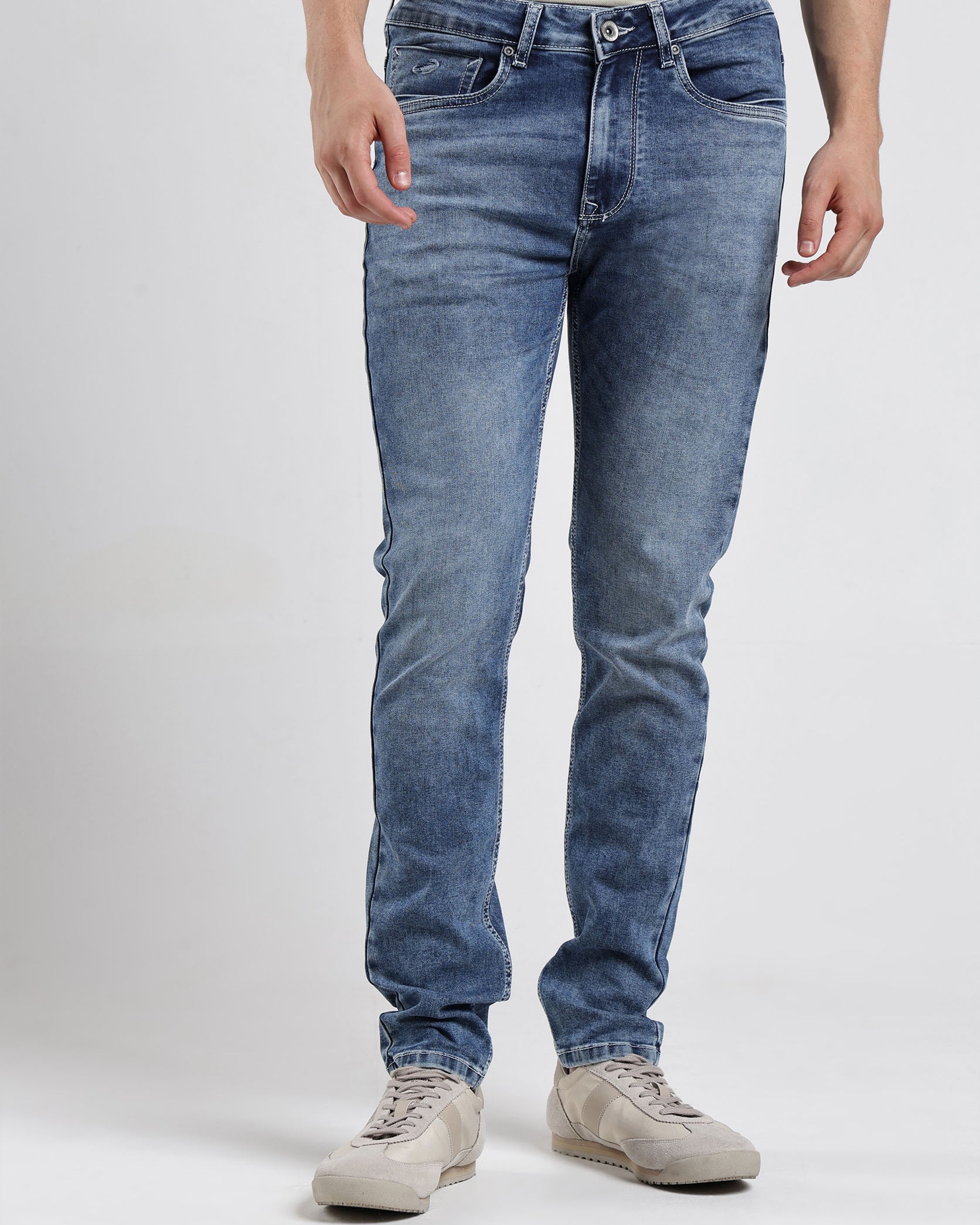 Person wearing blue jeans on a white background