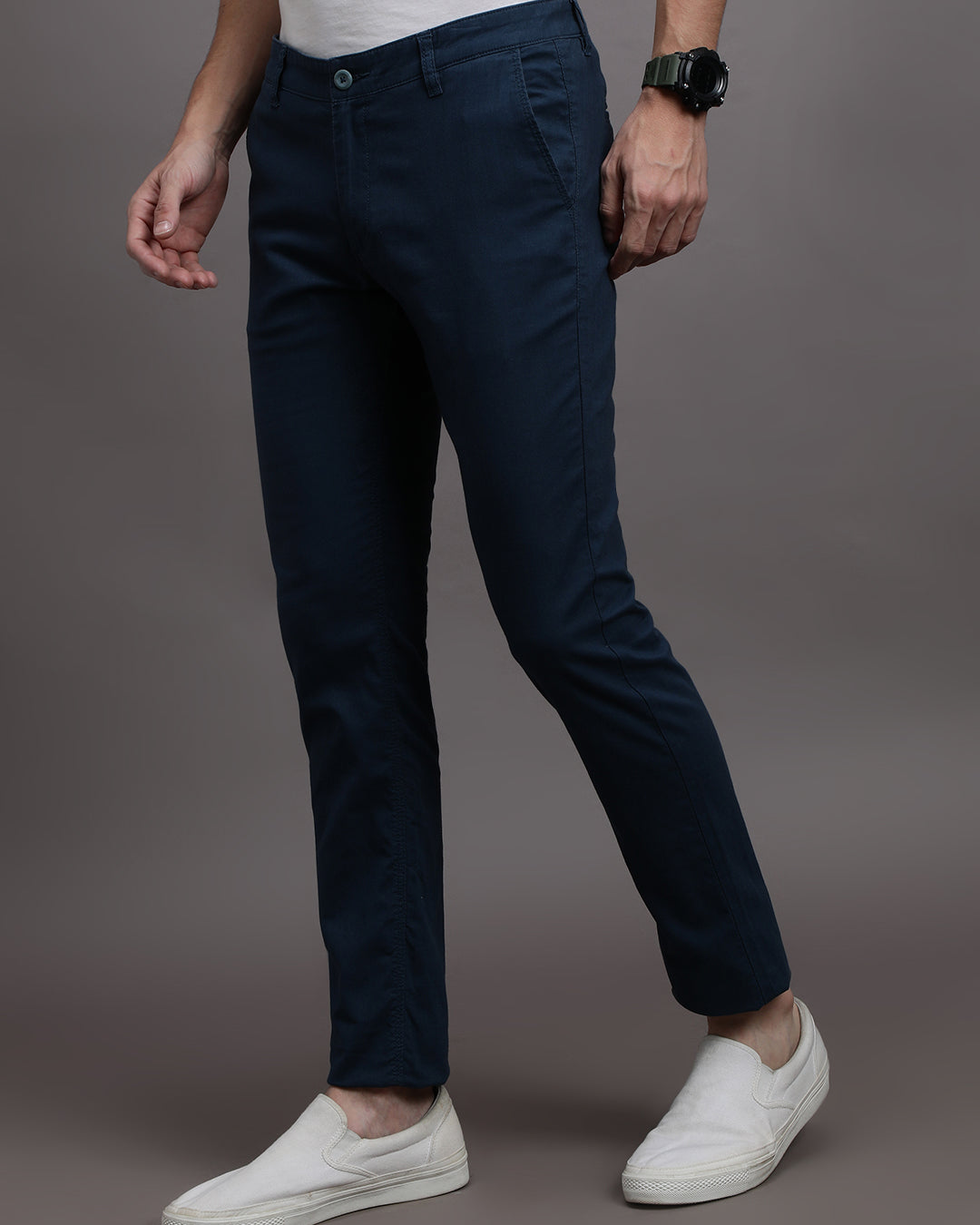 Man wearing a navy solid slim fit casual navy trouser on a light gray background