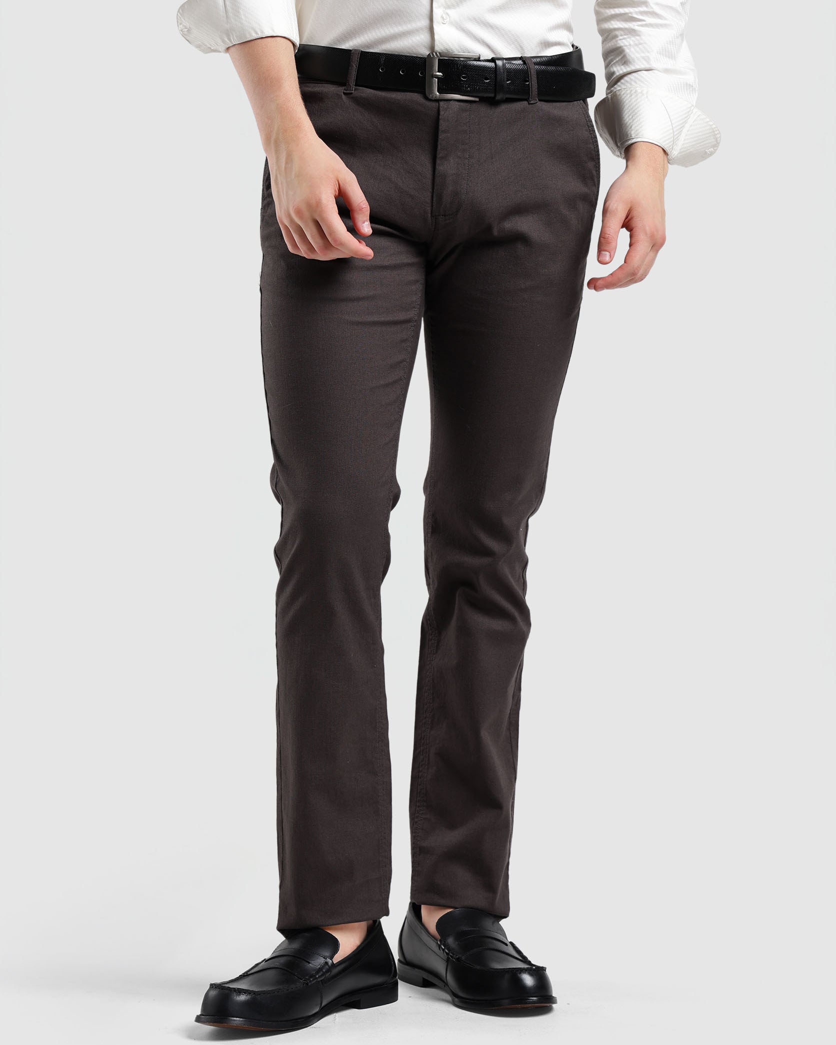 Person wearing a white shirt, dark gray pants, and black shoes on a white background