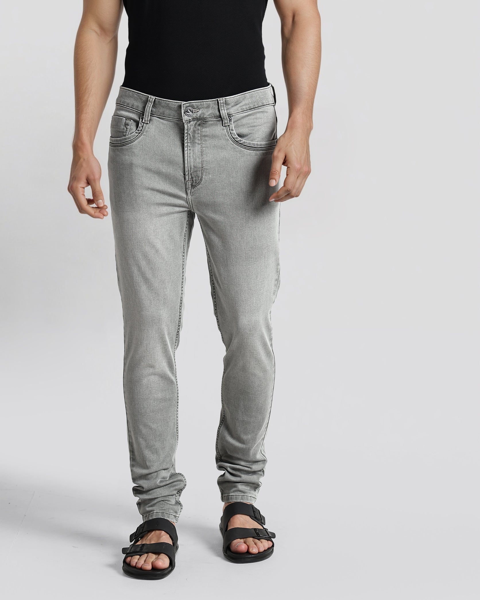 Person wearing gray jeans on a plain background