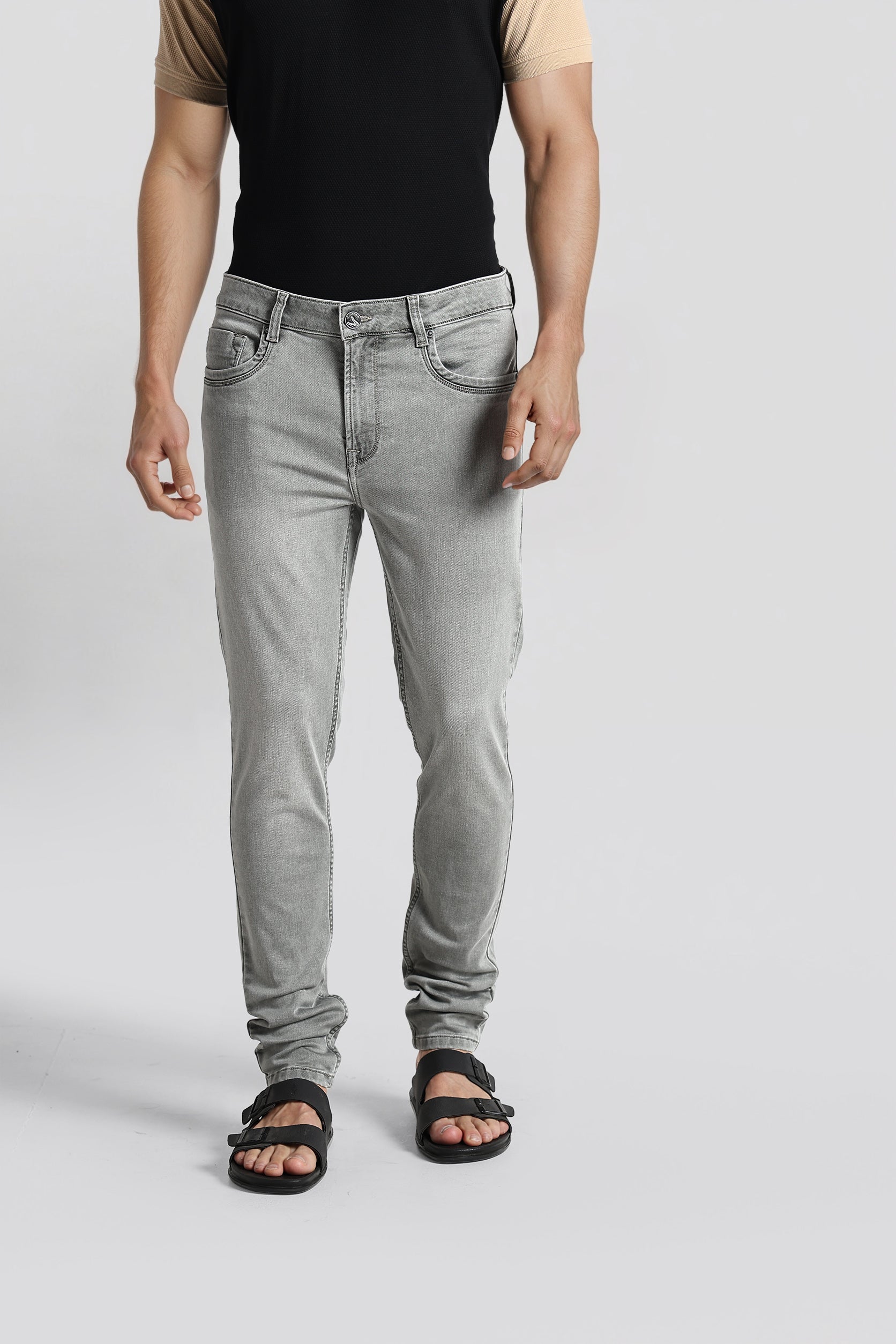 Person wearing gray jeans on a plain background