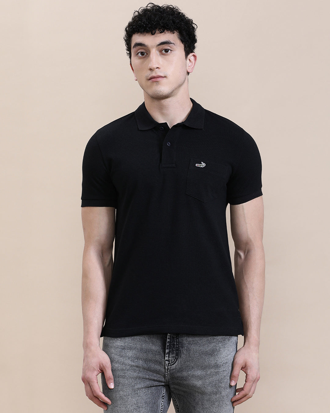 Man wearing a black casual solid black polo t shirt with pocket with casual styling on a gray background