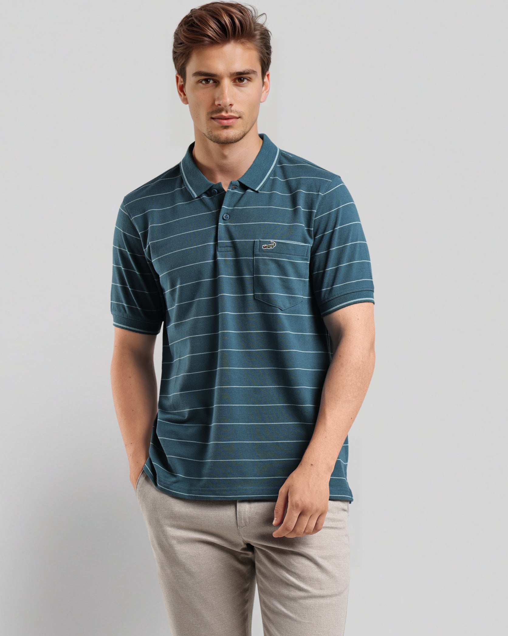 Man wearing a blue striped polo shirt and beige pants on a light gray background