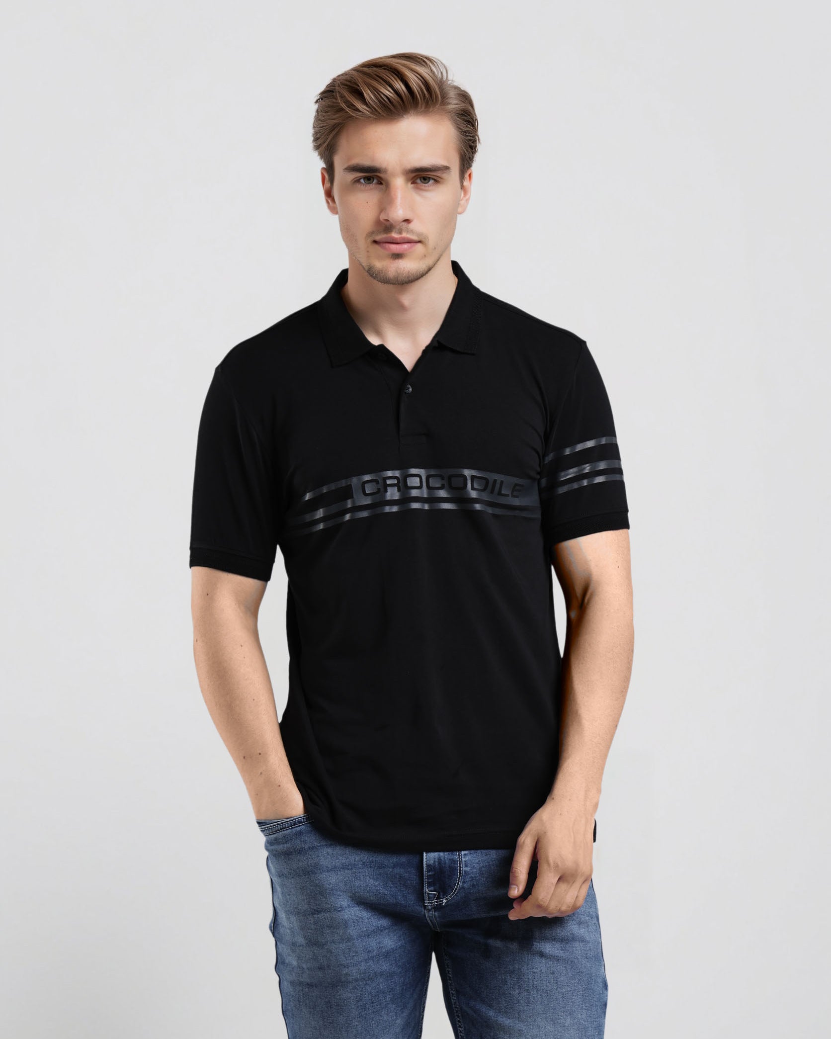 Man wearing a black polo shirt with a logo on a light gray background