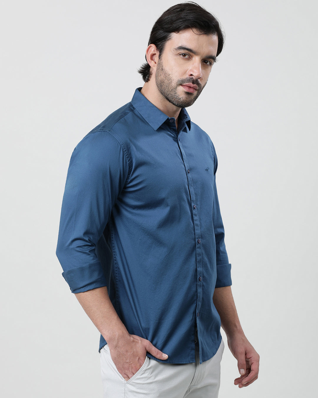 Man wearing a blue royal blue solid full sleeve 100% cotton shirt with casual styling on a gray background