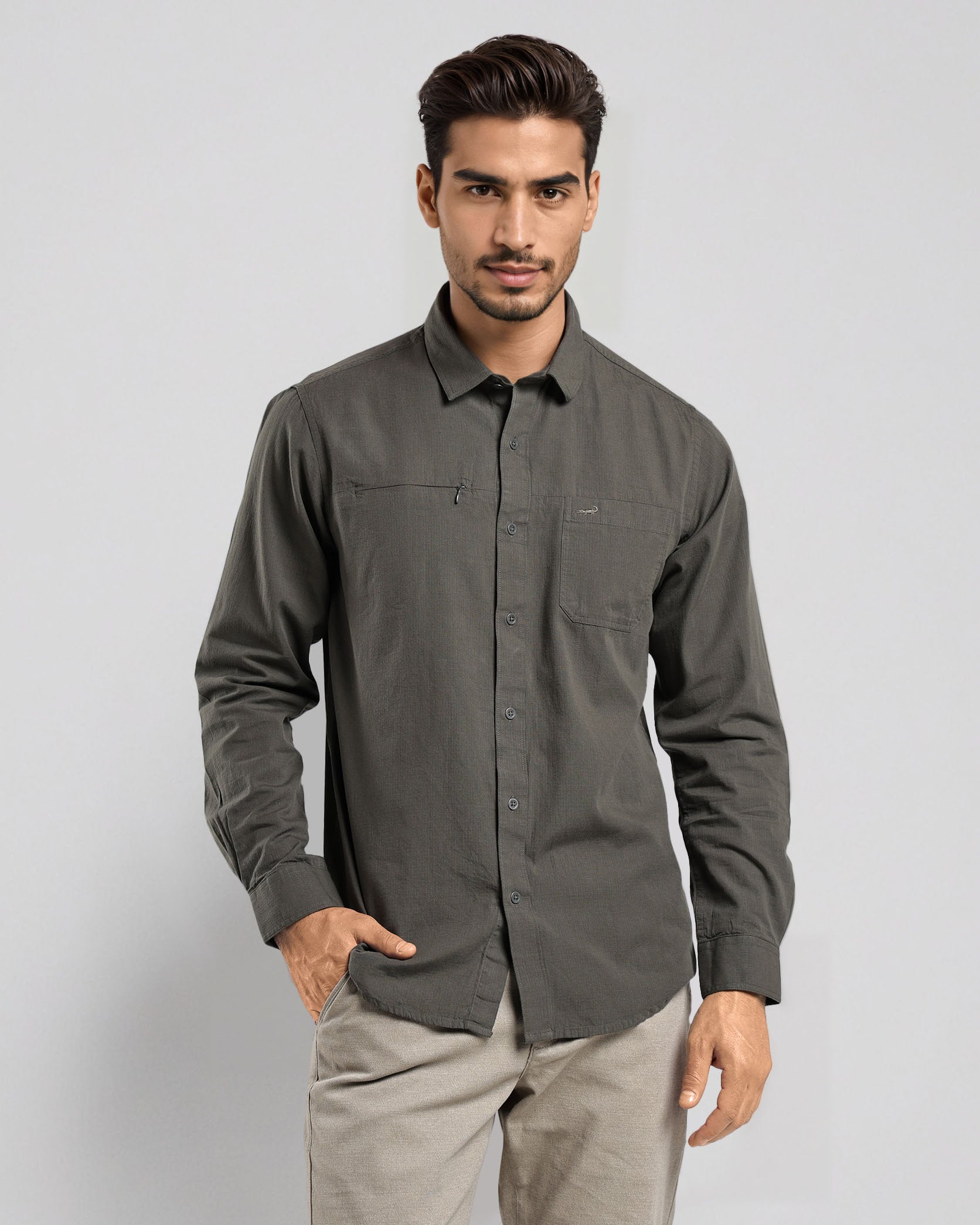 Man wearing a gray shirt and beige pants on a light gray background