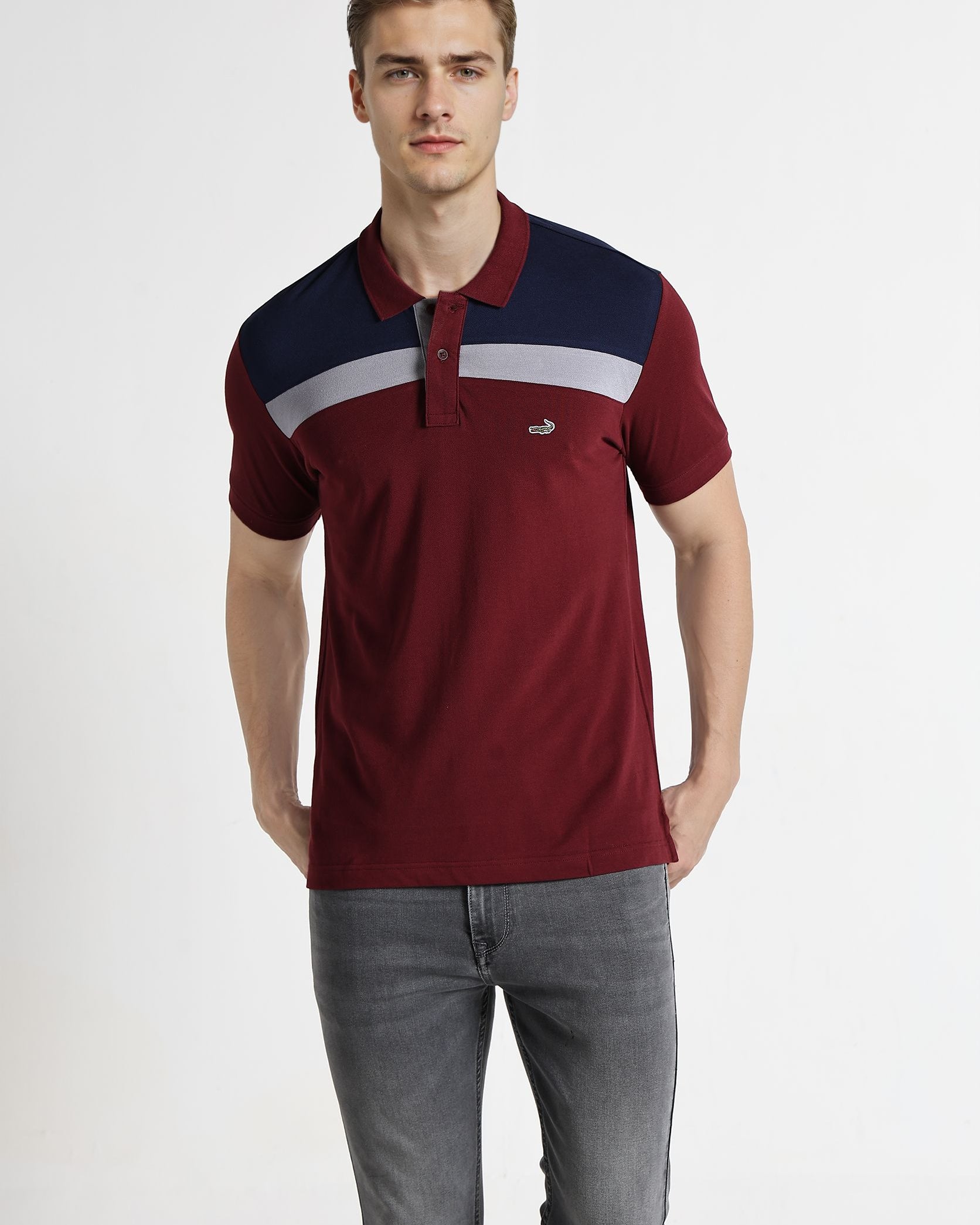 Man wearing a red and navy polo shirt with a white stripe on a white background