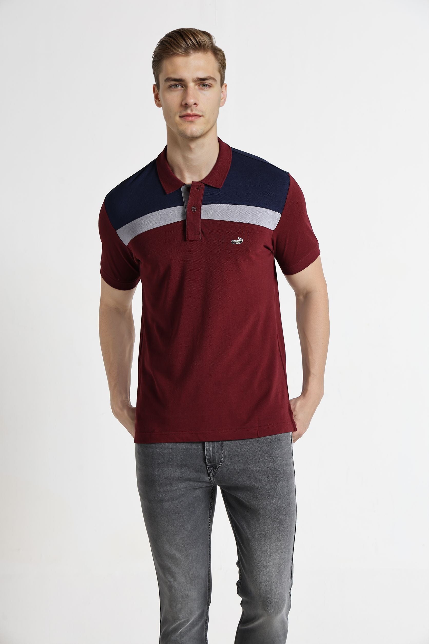 Man wearing a red and navy polo shirt with a white stripe on a white background