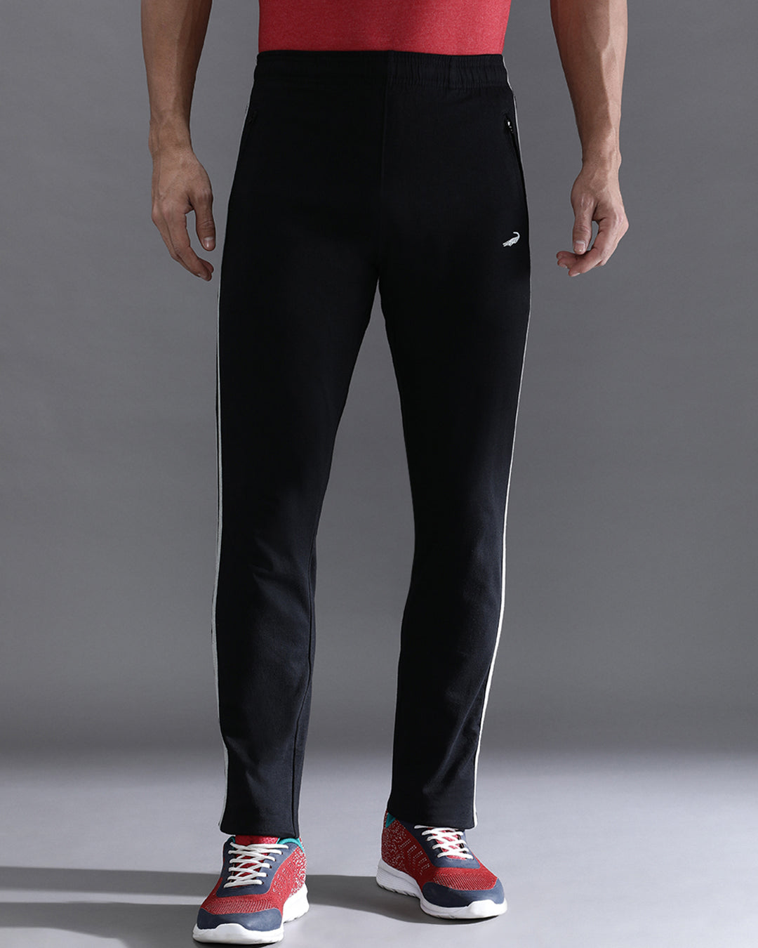 Person wearing black pants with a visible brand logo on a gray background