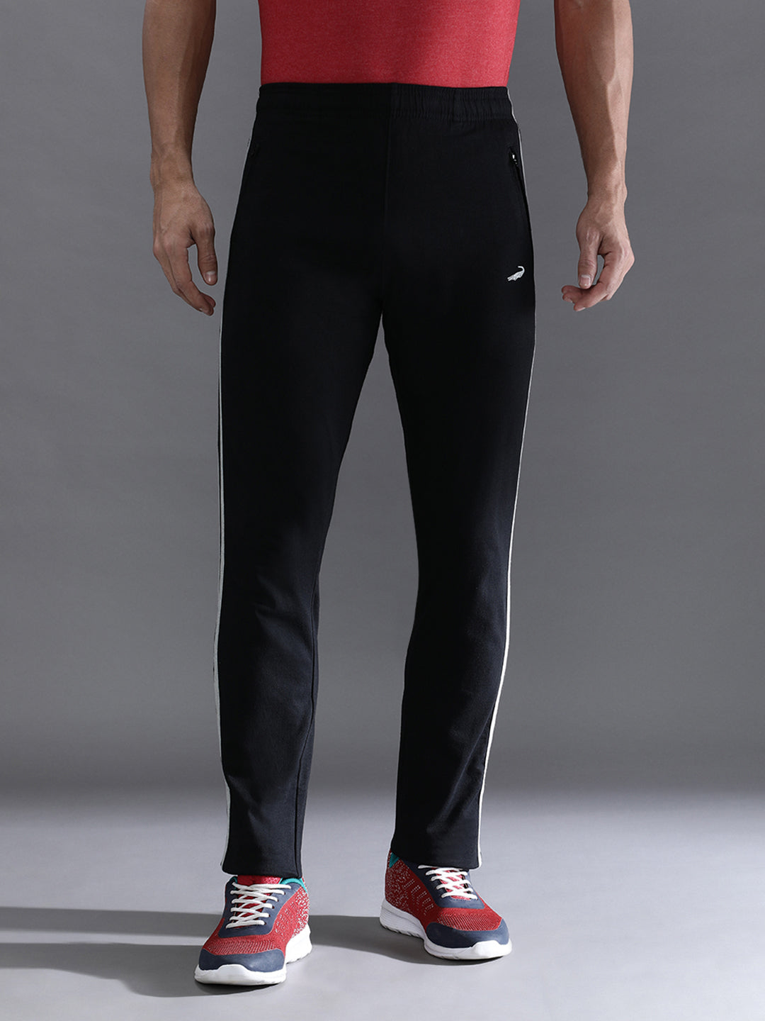 Person wearing black pants with a visible brand logo on a gray background