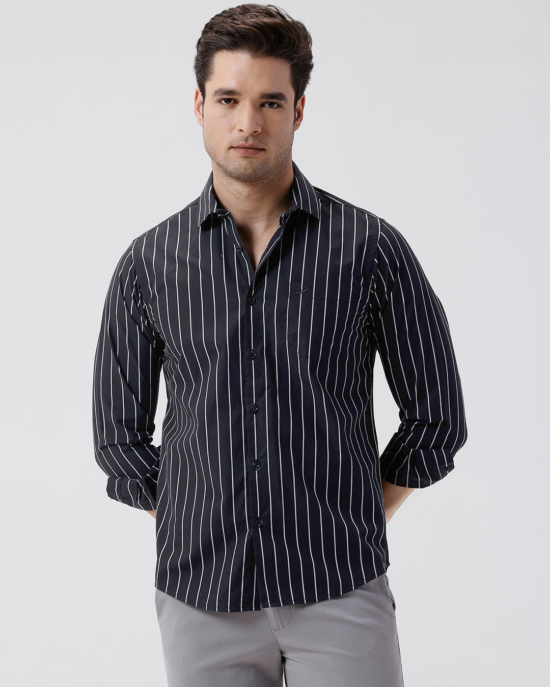 Man wearing a black black striper comfort fit casuals shirts on a light gray background