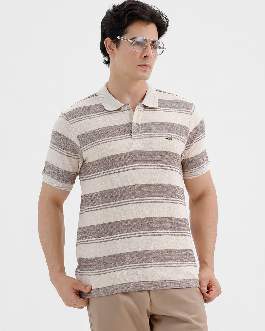 Man wearing a retro classic checked all over printed polo t shirt with casual styling on a gray background