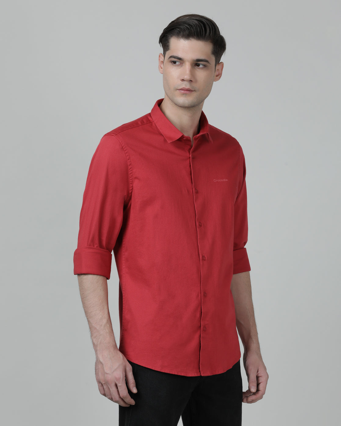 Man wearing a red tomato red solid full sleeve shirt on a light gray background