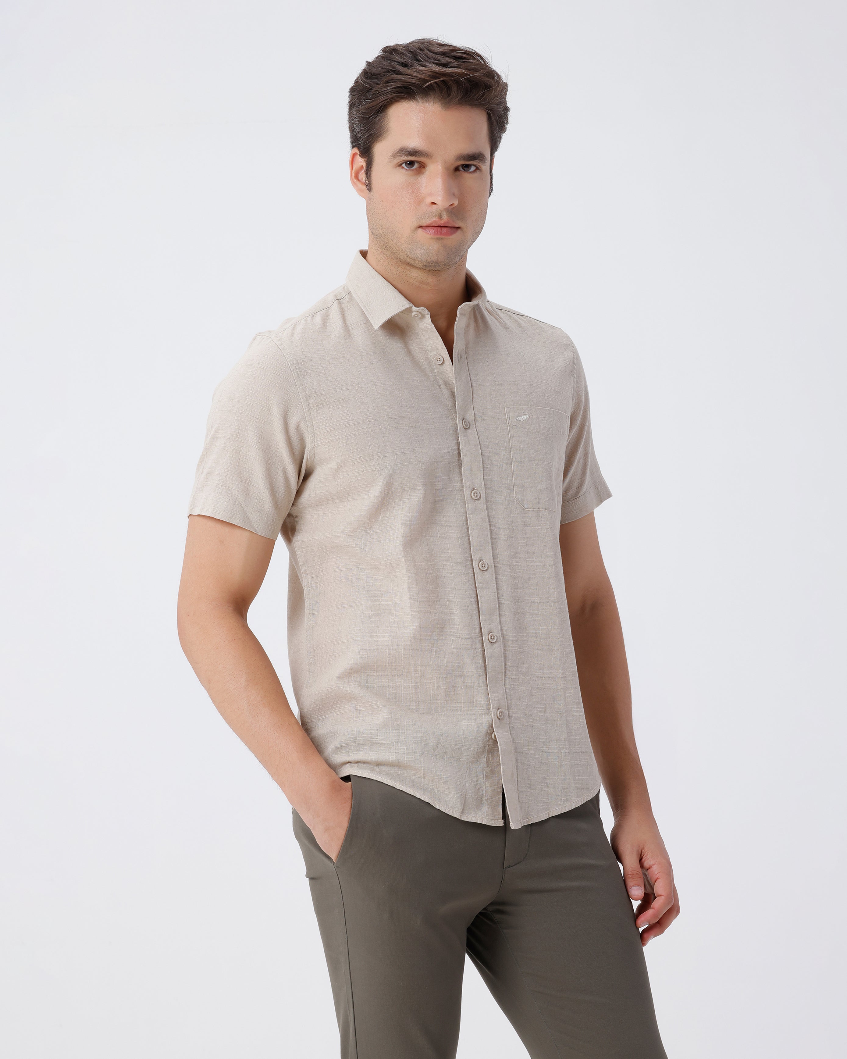 Man wearing a beige pure cotton textured shirt beige on a light gray background