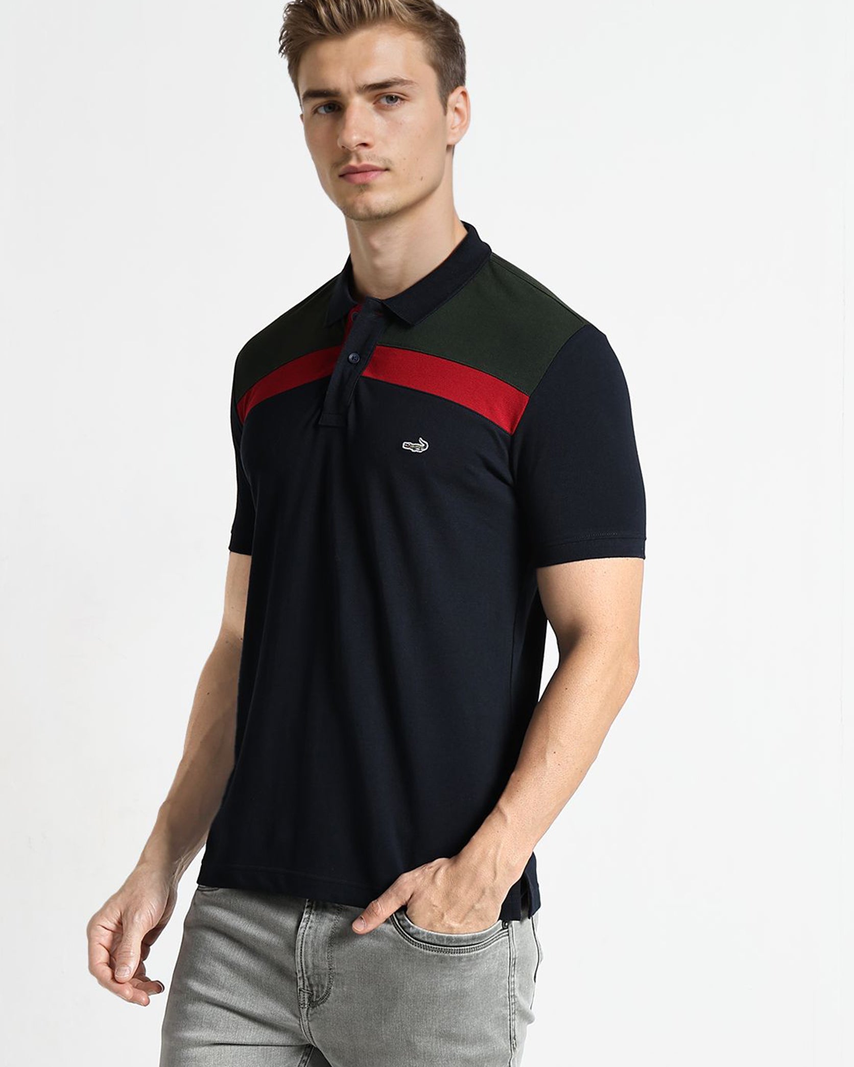 Man wearing a black polo shirt with red and green stripes on a white background