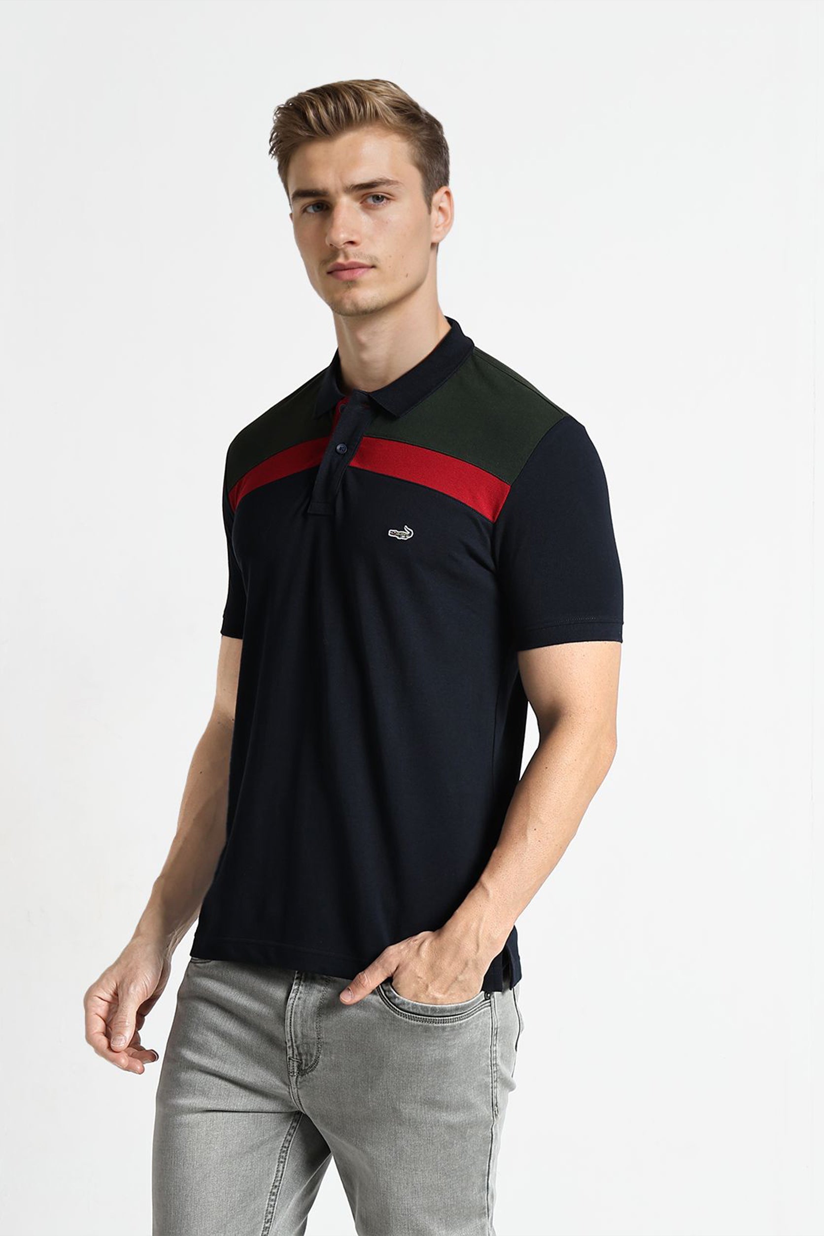 Man wearing a black polo shirt with red and green stripes on a white background