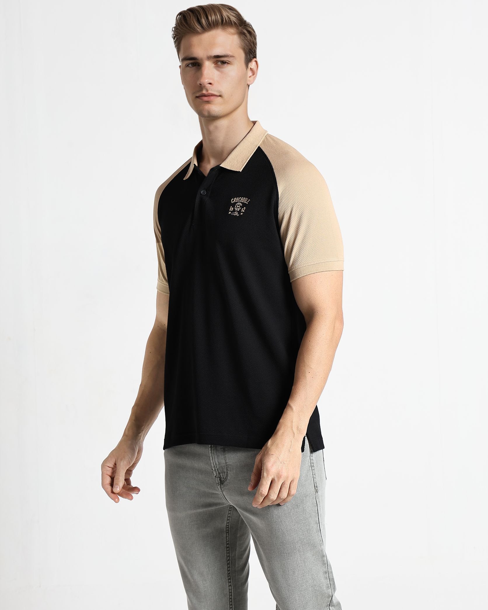 Man wearing a black and beige polo shirt on a white background