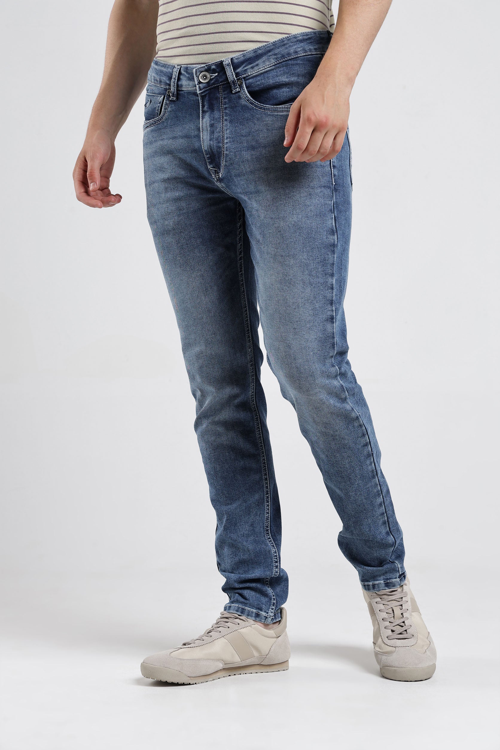 Person wearing blue jeans and a striped shirt on a white background