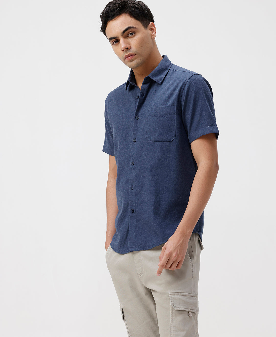 Man wearing a blue melange shirt solid blue on a light gray background