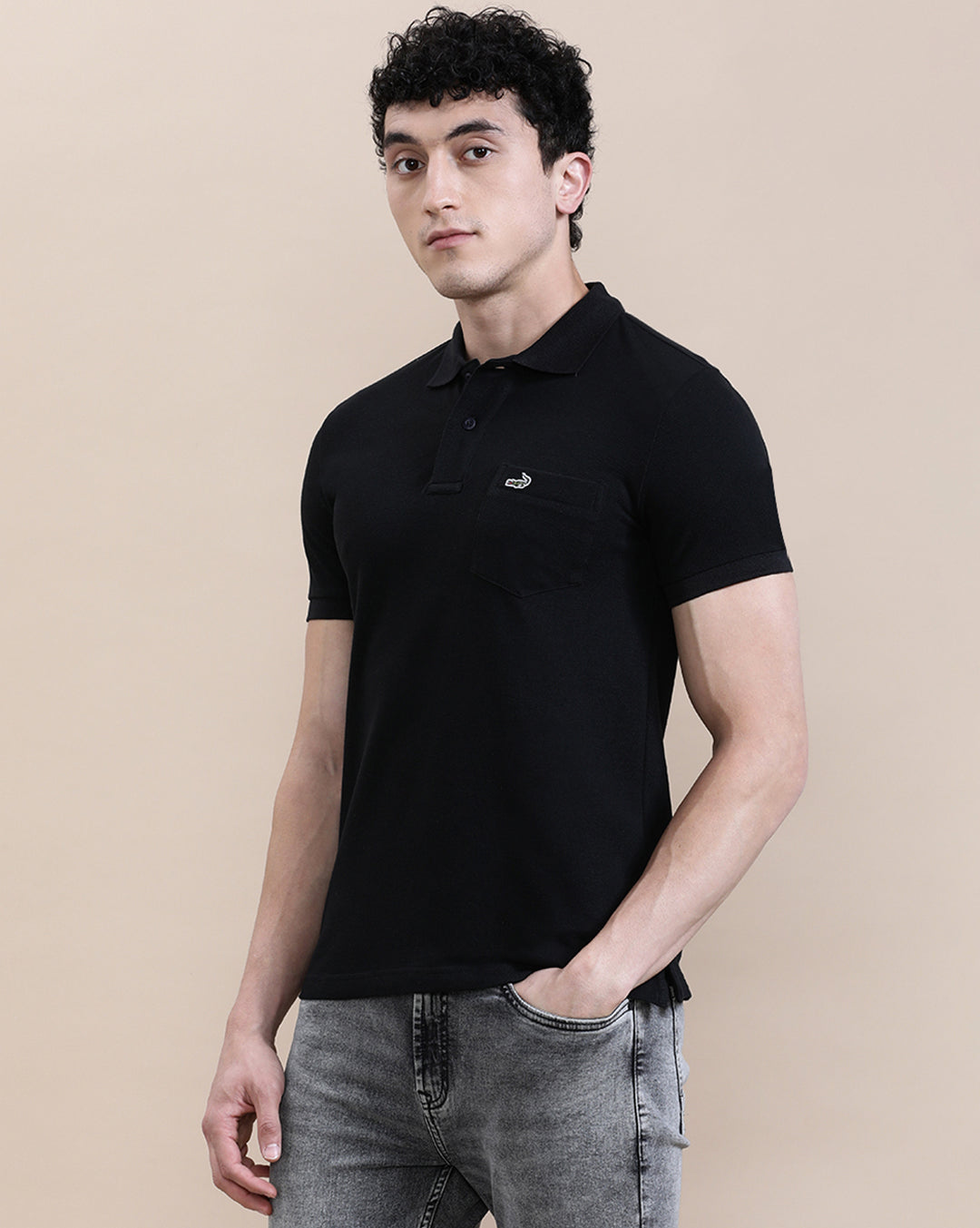 Man wearing a black casual solid black polo t shirt with pocket with casual styling on a gray background