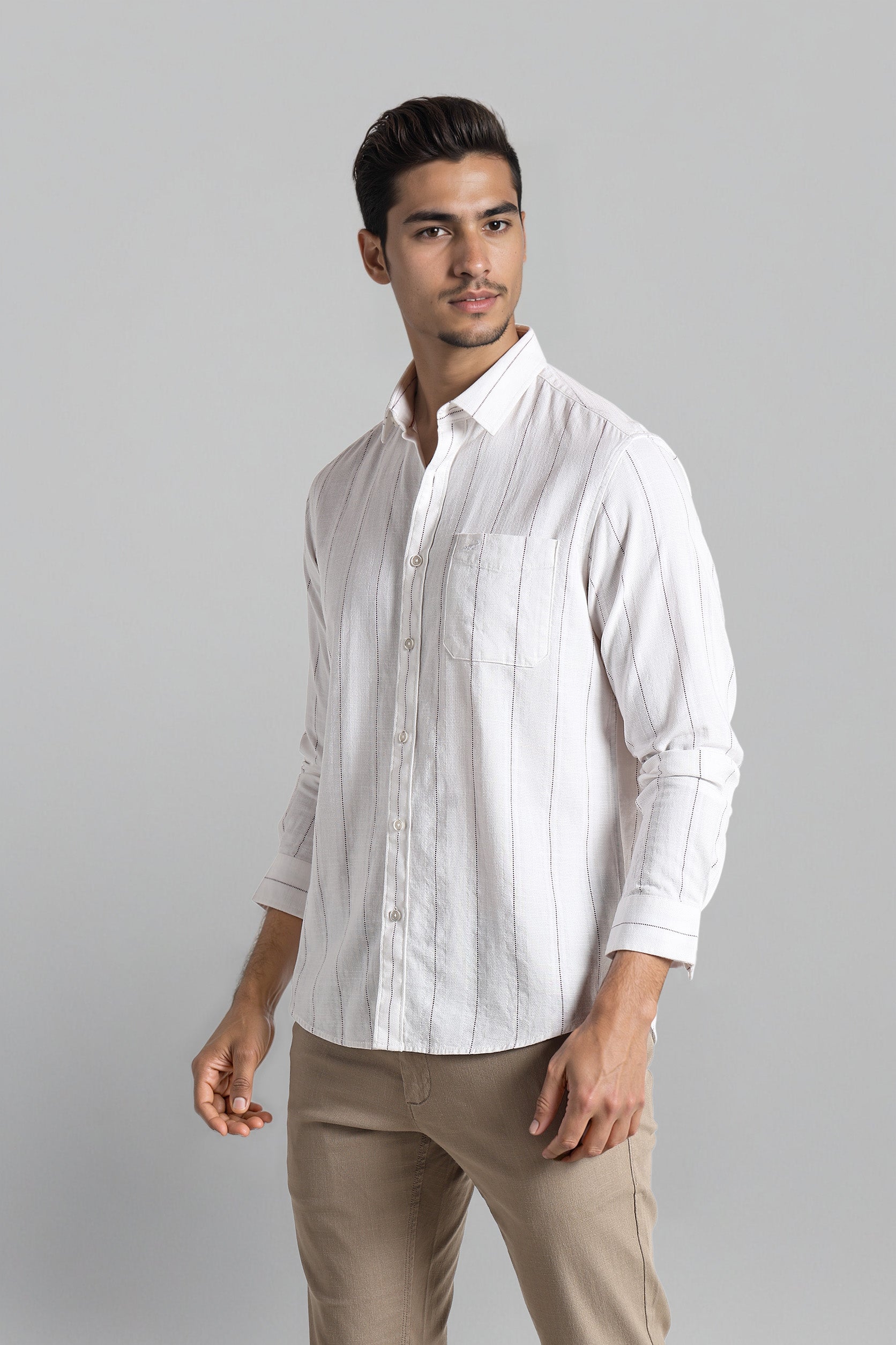 Man wearing a white striped shirt and beige pants on a gray background