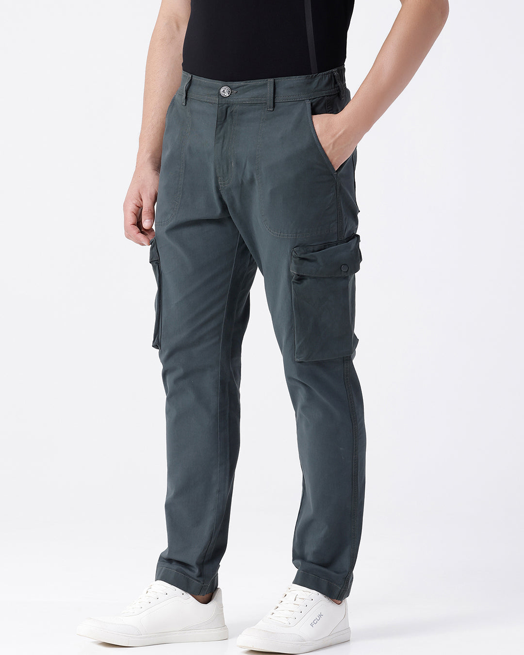 Man wearing a olive garment dyed cargo pant in olive with casual styling on a gray background