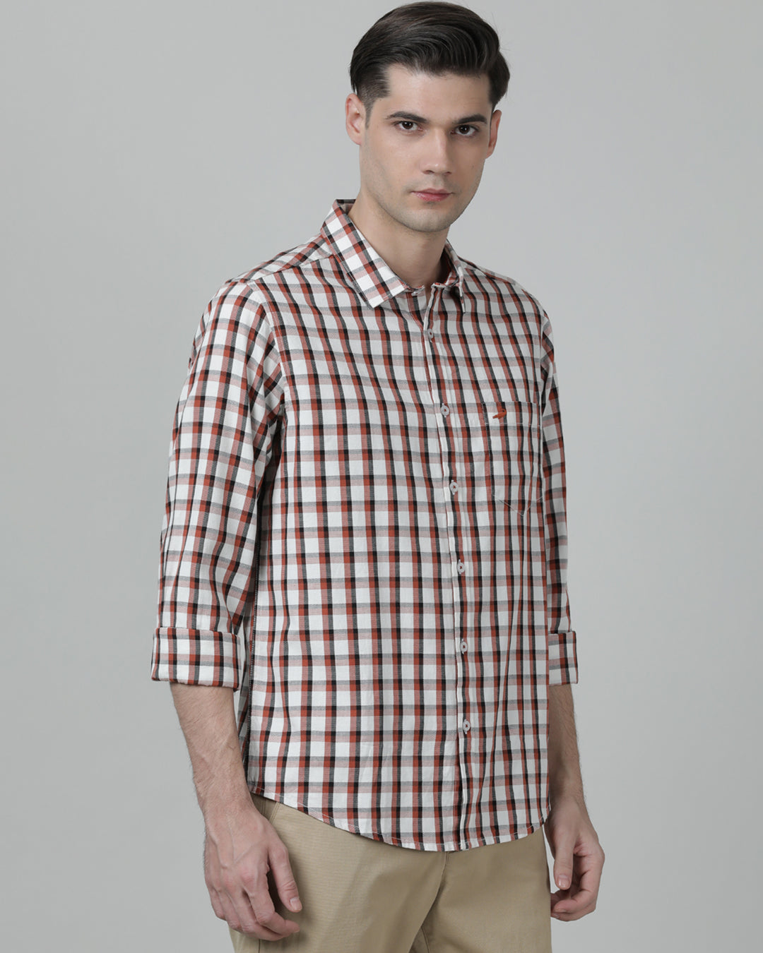 Man wearing a red brick red checked full sleeve 100% cotton shirt on a light gray background