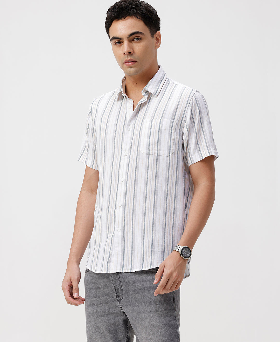 Man wearing a white white and green stripes comfort fit casuals shirts on a light gray background